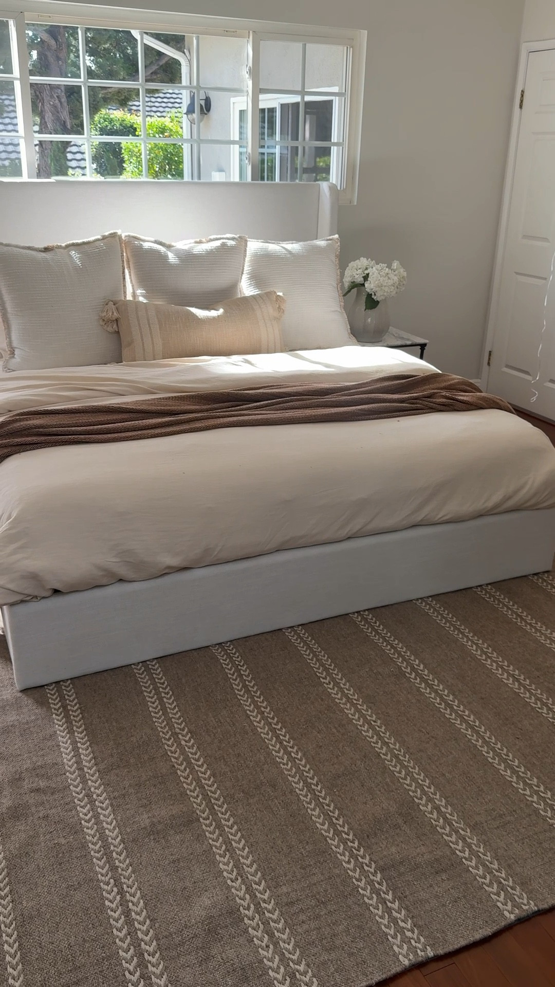 Pull that baby forward!! Typically 2/3 of your rug should be showing at the foot of your bed! 
Rug dimension guide:

Full/queen: minimum 5x8 (for bigger size rooms 6x9 or 8x10)
King: minimum 6x9 (for bigger size rooms 8x10 or 9x12)

