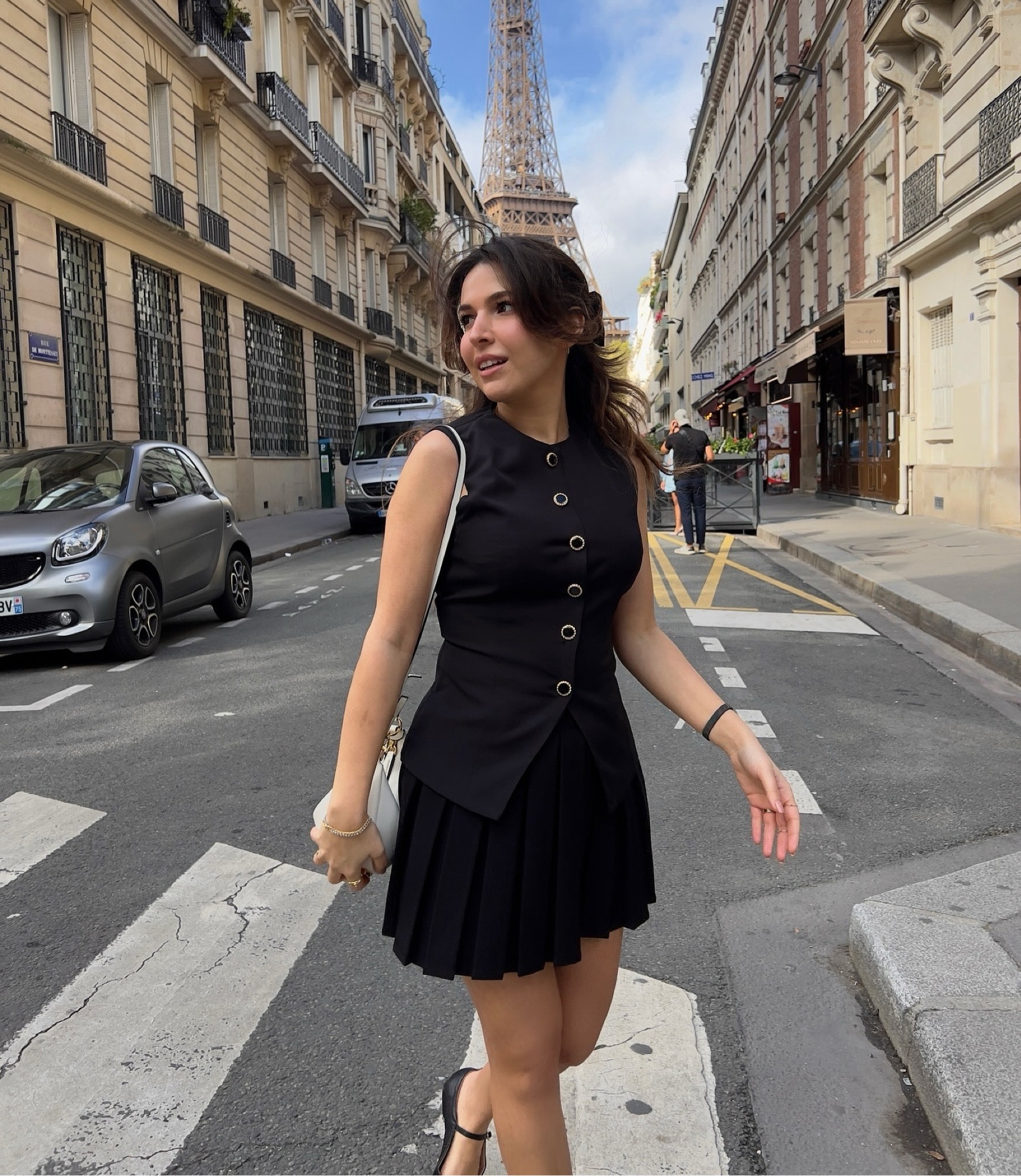 Black pleated skirt and black fitted vest outfit with velvet bow