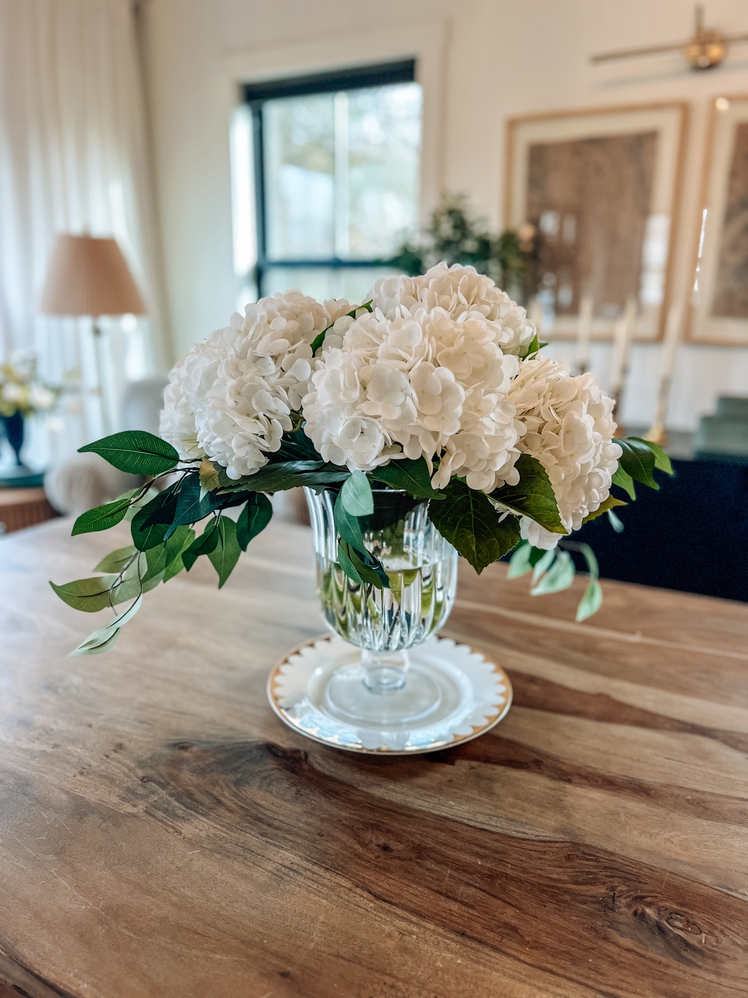 Faux hydrangeas, You’ll need three bunches (9 stems) to fill this vase. I also trimmed the stems to fit. I put some ficus stems in with the flowers, too. Add some water for a real life effect! These stems look and FEEL real! 

#LTKSeasonal #LTKhome