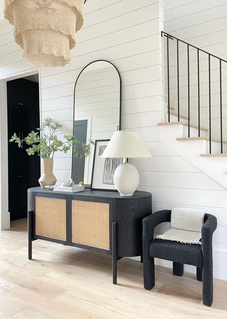 Home decor.  Entryway decor.  Foyer decor.  White lamp.  Black credenza.  Cane furniture.  Cane credenza.  Black arched mirror.  Home accessories.  Boucle chair.  Green stems.  Faux stems.

#LTKunder100 #LTKFind #LTKhome