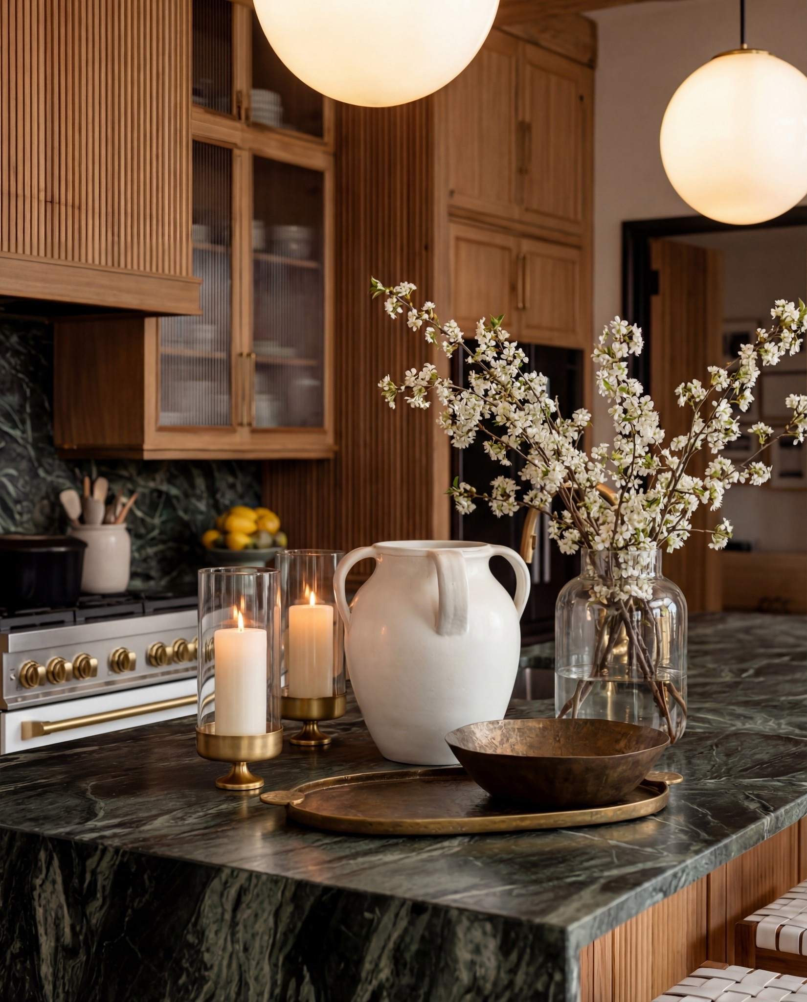 Shop the Look:
• Dark green marble waterfall island (forest + charcoal tones)
• Vertical slat wood kitchen cabinets (light natural oak)
• Boucle and oak modern counter stools
• White globe pendant lights (antique brass rod)
• Brass hardware + brass appliance knobs
• White gas range with brass details
• Textured ceramic pitcher + matching countertop décor
• Gold tray + candle set
• Dark wood bowl (centerpiece accent)
• Vintage-style runner (taupe, beige, soft charcoal pattern)

Black Friday

#LTKSaleAlert #LTKCyberWeek #LTKHome