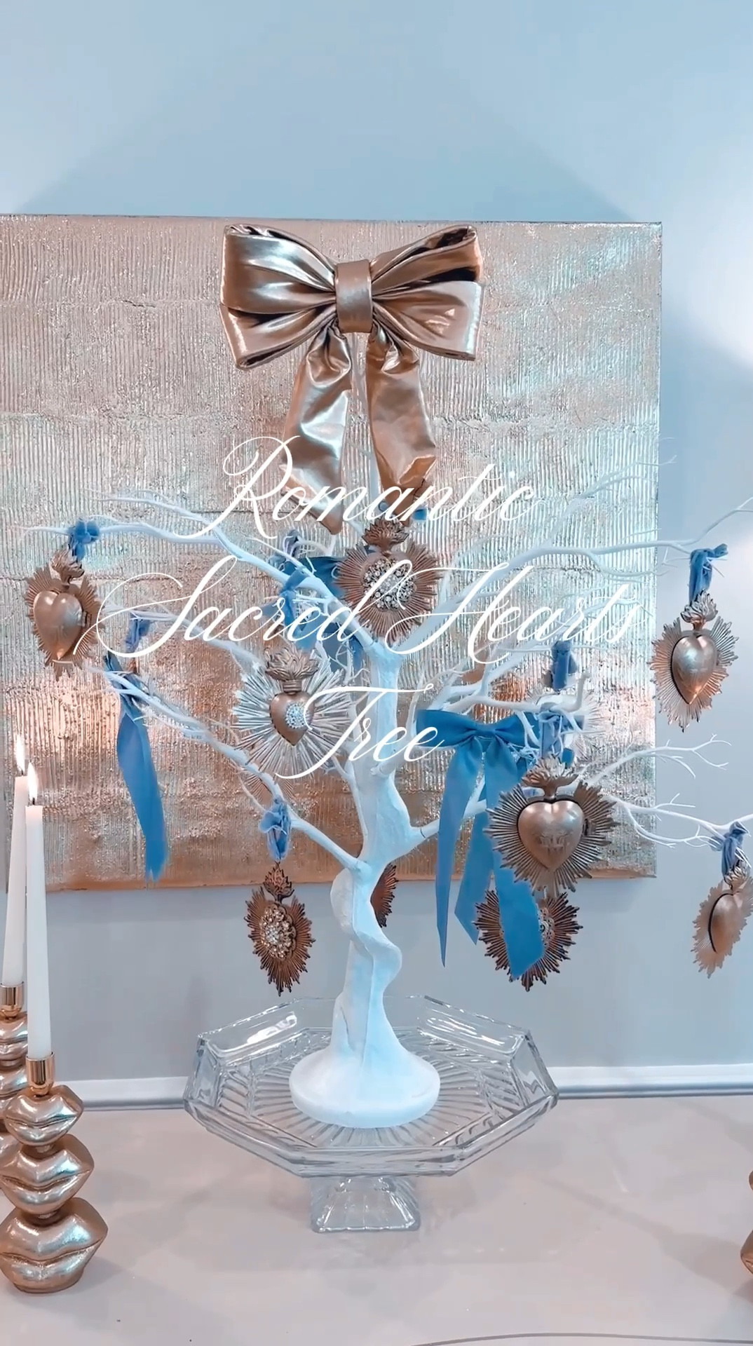 I created this romantic tree adorned with exquisite Sacred Heart ornaments, and delicate baby blue satin ribbons. As a base, I used a white manzanita tree, adding the ornaments one by one and filling the empty spaces with charming bows. The result? Airy, elegant, and perfectly romantic—now sitting proudly in my dining room.
To elevate the look, I placed it on a crystal cake stand to add height and surrounded it with glamorous gold ‘lips’ candleholders. This setup is ideal for Valentine’s Day or any romantic occasion, from bridal showers to baby showers. Next time, I might experiment with other colors for a fresh twist! Don’t you think it’s delightfully unique?


#LTKParties #LTKHome #LTKSeasonal