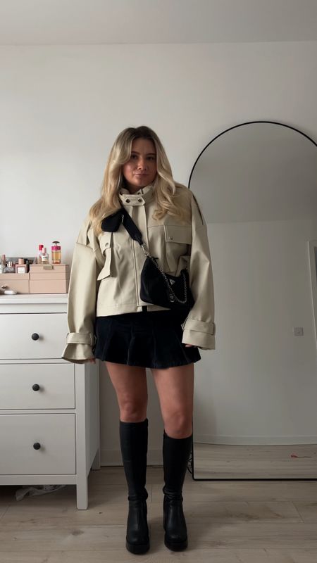 spring outfit featuring a corduroy grey micro pleated skirt, a black ribbed long sleeve top, black chunky knee high boots, a neutral oversized biker jacket and prada cross body nylon bag

#LTKeurope #LTKstyletip #LTKitbag