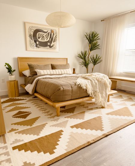 Boho primary bedroom 😍 New art and rug! We absolutely love our bed that gives off a mid century modern vibe  

#LTKsalealert #LTKstyletip #LTKhome