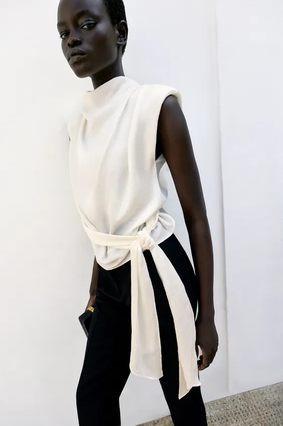 Sleeveless top with a high neck, shoulder pads and pleats. Featuring a knot detail at the hem and... | Zara IT