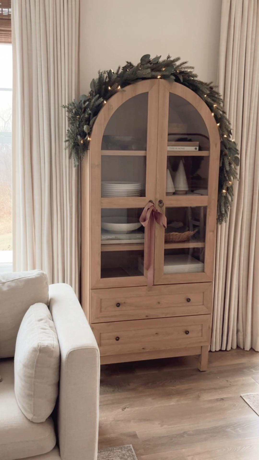 Love decorating this cute arched cabinet for Christmas! I just added some garland, lights and a bow on the door handle. The garland is a combination of 3 so it would be nice and full. 

#LTKHome #LTKHoliday #LTKSeasonal