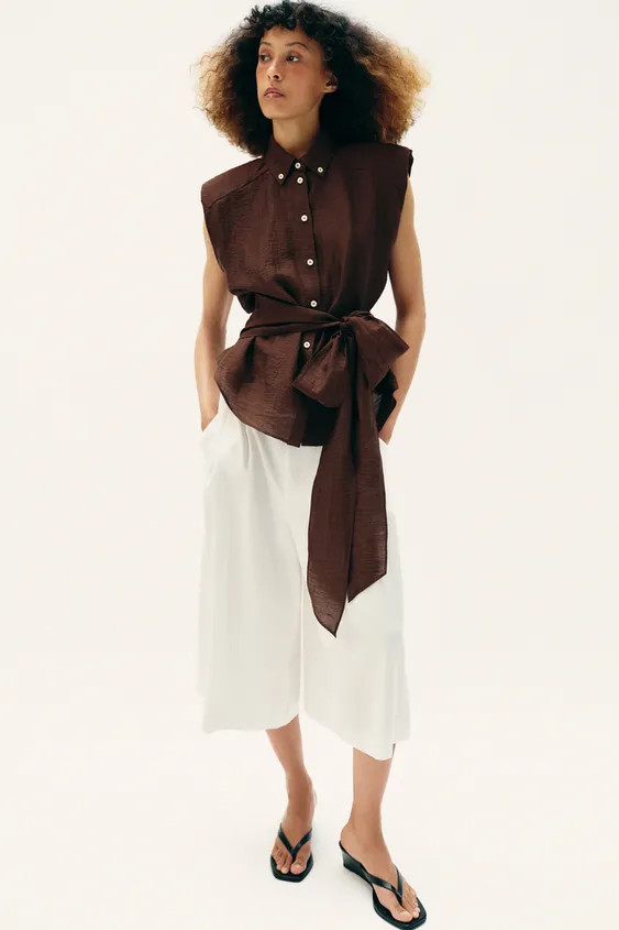 Top made of linen. Lapel collar and sleeveless with shoulder pads. Front button closure and tied ... | Zara US