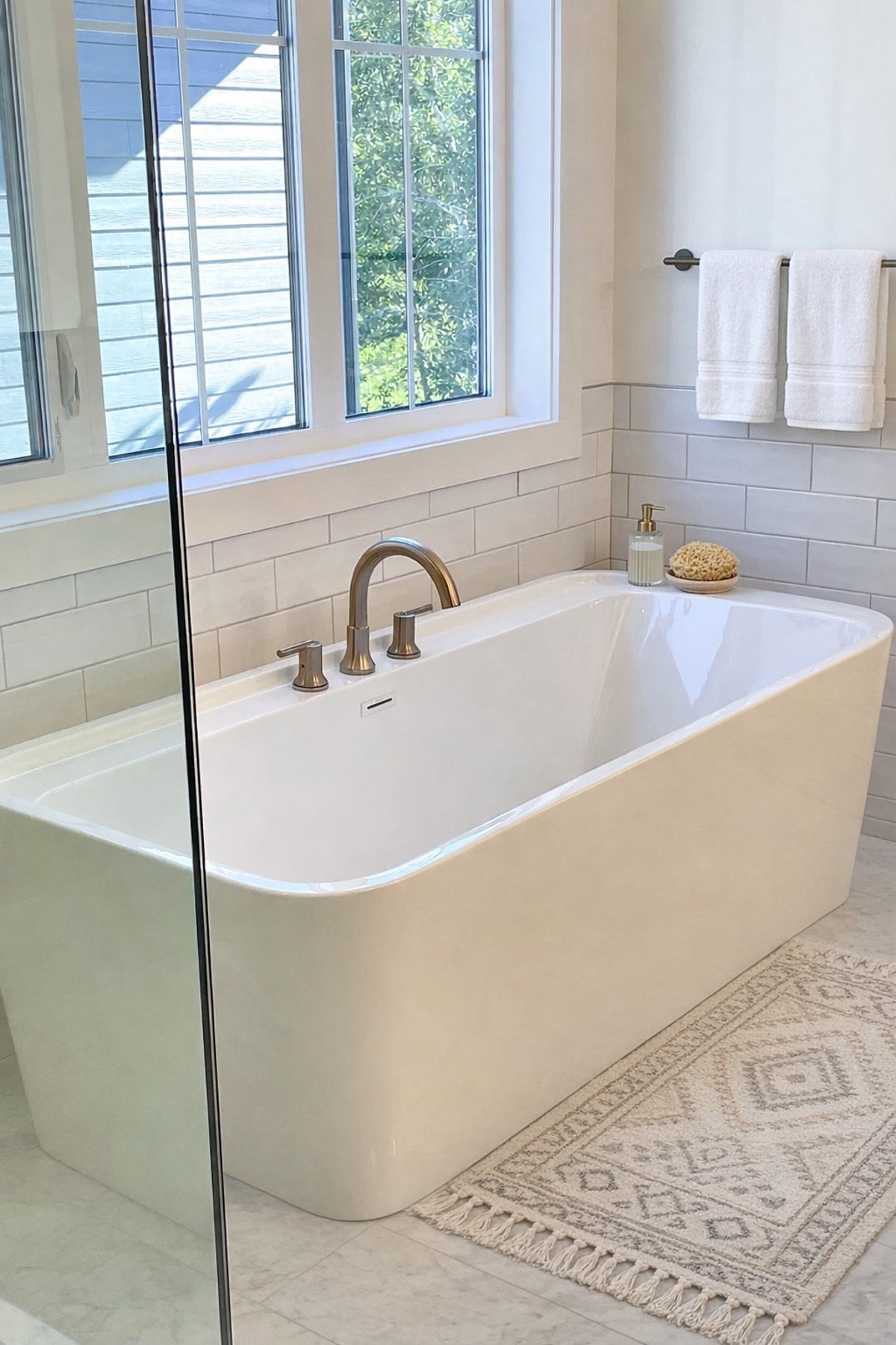 Styling our bathroom tub area with a few simple layers. I wanted to keep the overall vibe modern and calming, so I started with a neutral patterned bath mat, added classic white towels for that clean, spa-like feel, and brought in a ribbed glass soap dispenser for a little sparkle. It’s amazing how a few small details can make the whole space feel more finished and inviting.

#LTKHome #LTKselfcare #LTKSaleAlert