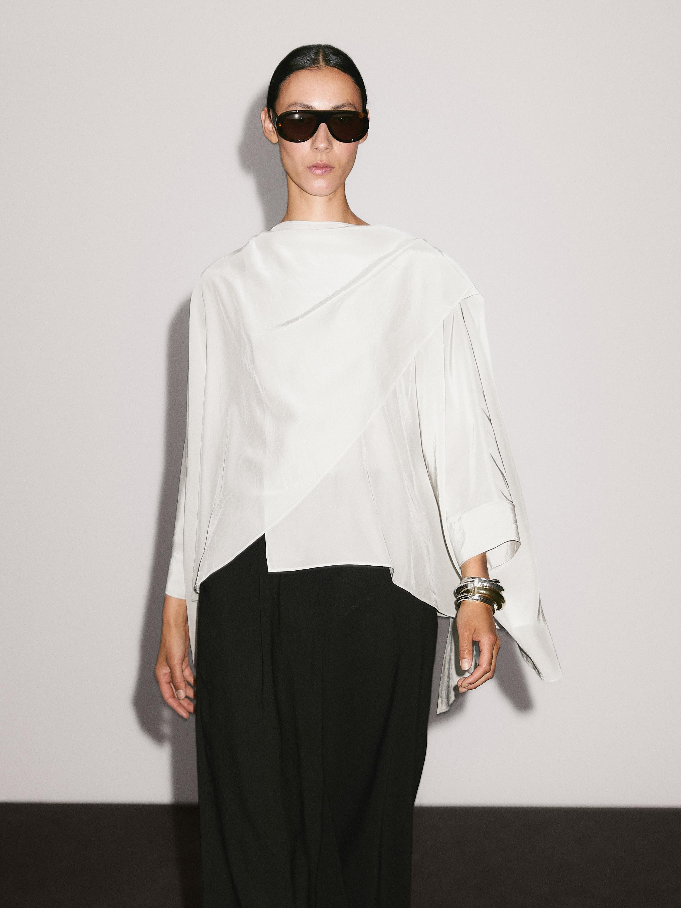 Kurzes Cape aus fließendem Gewebe. Lange Ärmel. Asymmetrischer Schnitt. Geknöpfter Rundausschn... | Massimo Dutti DE