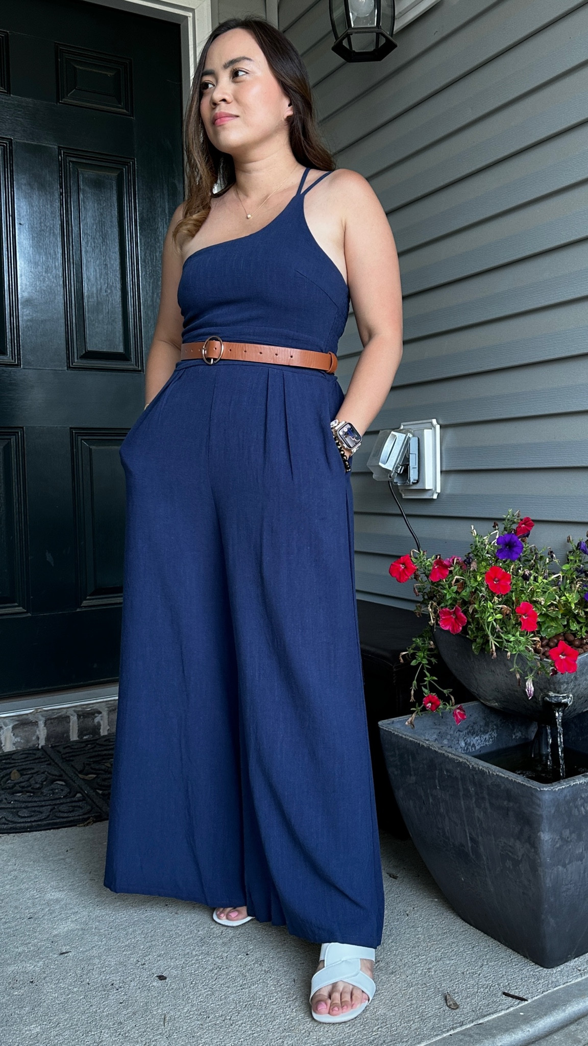 Dress up your navy blue wide leg jumpsuit by adding a touch of elegance with a brown belt to cinch the waist, creating definition and contrast. Pair it with chic nude sandals for a polished look that elongates the legs. Carry a sleek black clutch bag for a sophisticated accessory that complements the navy blue hue. Finish off the ensemble with rectangular black sunglasses for a dash of glamour and a hint of mystery. This combination balances sophistication with a touch of modern flair, making it a timeless fashion statement.

#LTKstyletip