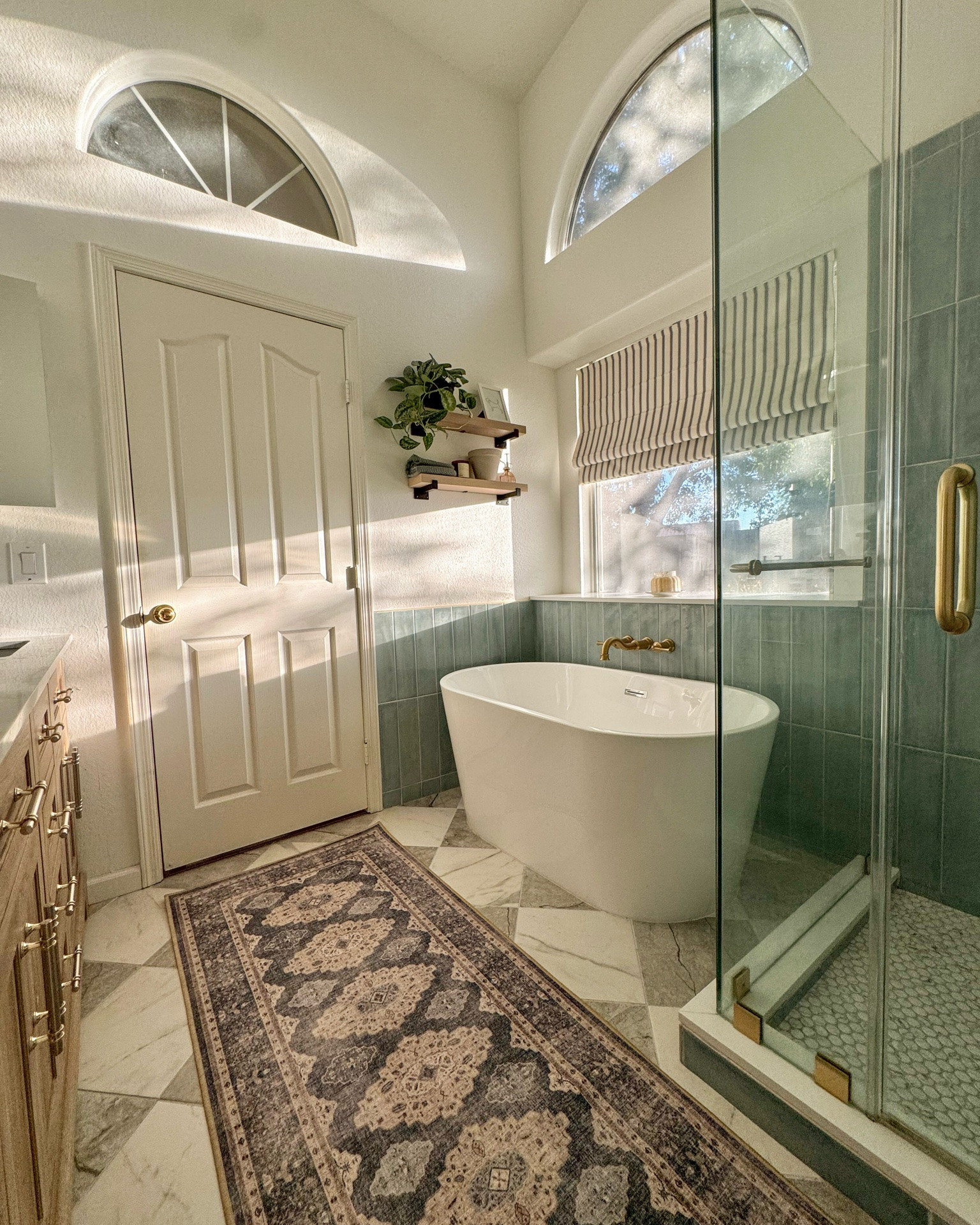 our primary bathroom makeover featuring grey and white marble look porcelain checkered tiles, standing tub, glass shower, blue wall tile and fresh decor

#LTKHome #LTKSaleAlert