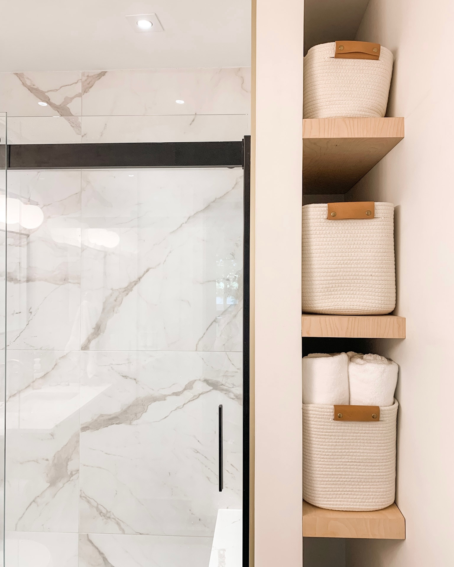 Keeping with our black, tan, neutral, leather theme… wood bathroom shelves for extra storage.  Love these cotton coiled baskets - they keep their shape but can also squeeze into smaller spaces. Black frameless shower doors. 

Home decor
Organization
Storage
Faux leather
Neutrals
Wood shelves
Shelf styling
Bathroom

#LTKunder50 #LTKfamily #LTKhome