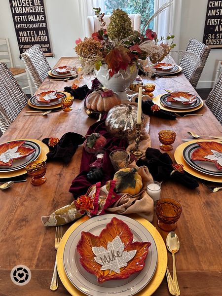 Thanksgiving table decor. White dinner plates with black edging, leaf plates, gold flatware, black and fall batik napkins, gold cut glass cups with handles. Velvet and silk fabric as a runner, faux pumpkins, large beautiful pottery for centerpiece. #thanksgivingtable #tabletop #tabledecor ##centerpiece 

#LTKHoliday #LTKhome #LTKSeasonal