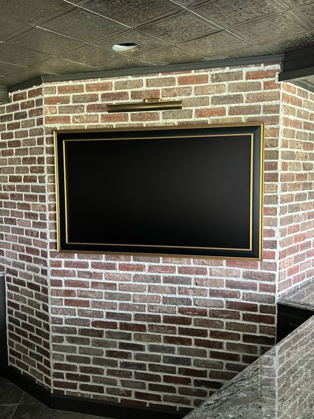 Frame TV and frame for our basement! Love the picture light above it! 

#LTKsalealert #LTKhome #LTKstyletip