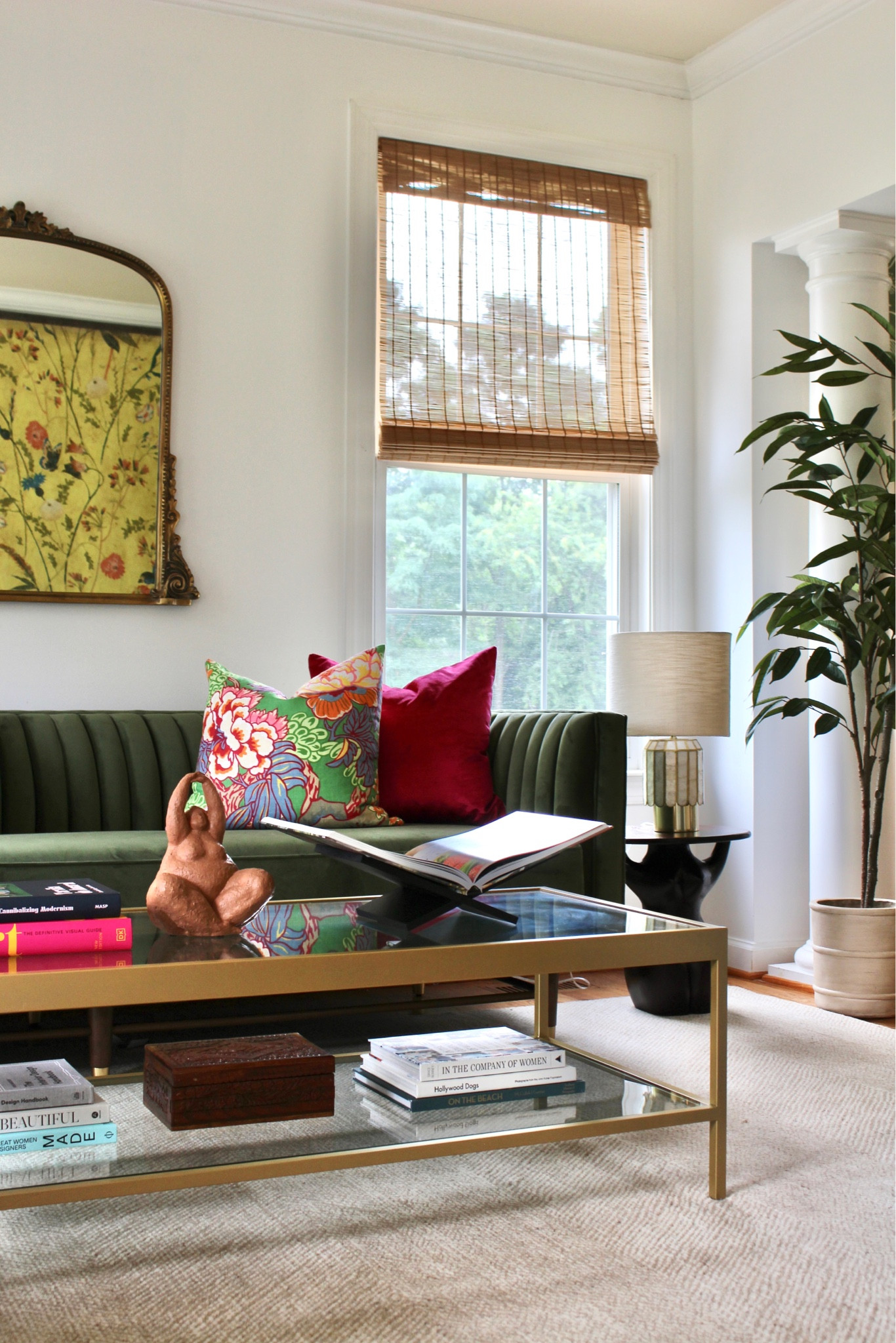 Bright and fun living room! Formal sitting room. Cocktail room. Velvet green sofa. Ornate wall mirror. Fun pillow covers. Glass coffee table. Faux tree. Table lamps. Area rug  

#LTKunder100 #LTKsalealert #LTKhome