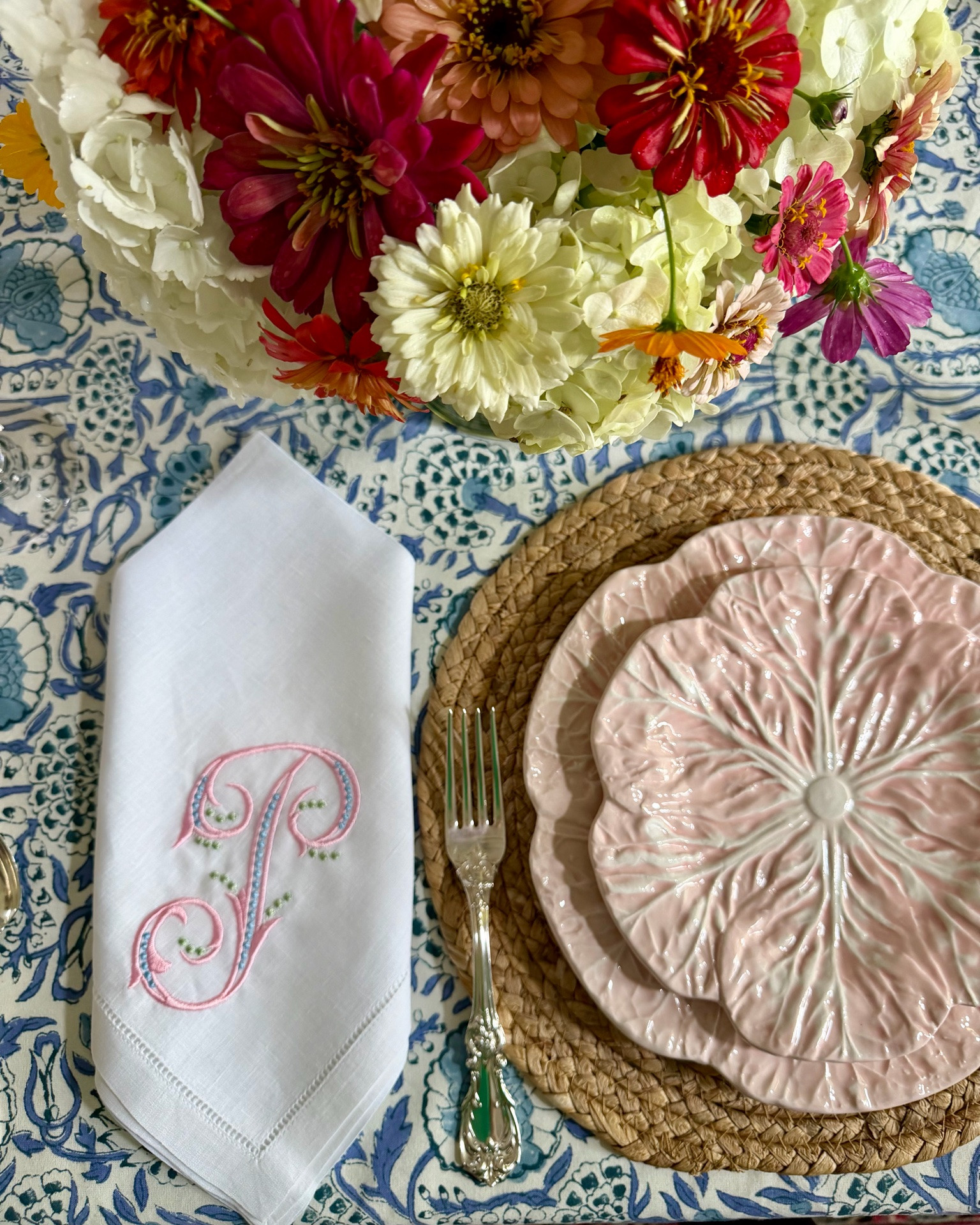 I wish the lighting was better so you could see these beautiful bright colors! I loved taking last week’s hydrangeas and adding zinnias and cosmos from my garden for the centerpiece. I used one of my favorite blue and white tablecloths with pink cabbage plates, gorgeous
embroidered napkins, and our silver. It makes for a fun end of summer table! 🩷