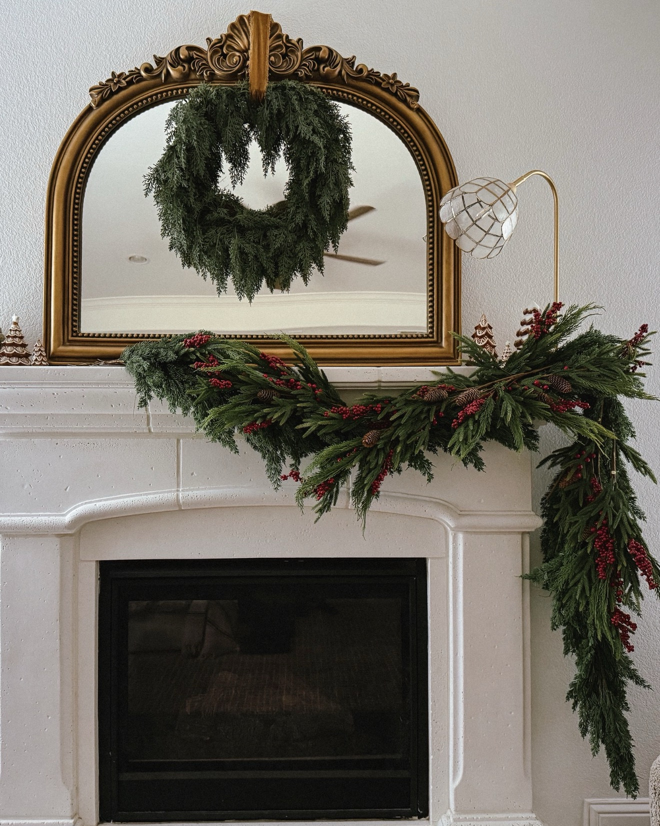 Christmas mantel, Afloral, cedar garland, pine cone and berry branch, faux stems, upholstered storage bed, wall mirror, ottomans, wool checkered rug

#LTKHome #LTKHoliday