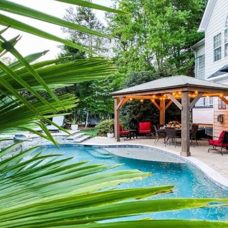 Outdoor pool patio entertaining space. Stay cool under a cedar gazebo with sun shades and outdoor portable ceiling fans. Create a seating area with chaise loungers and outdoor rocking chairs. 

#LTKhome #LTKstyletip #LTKSeasonal