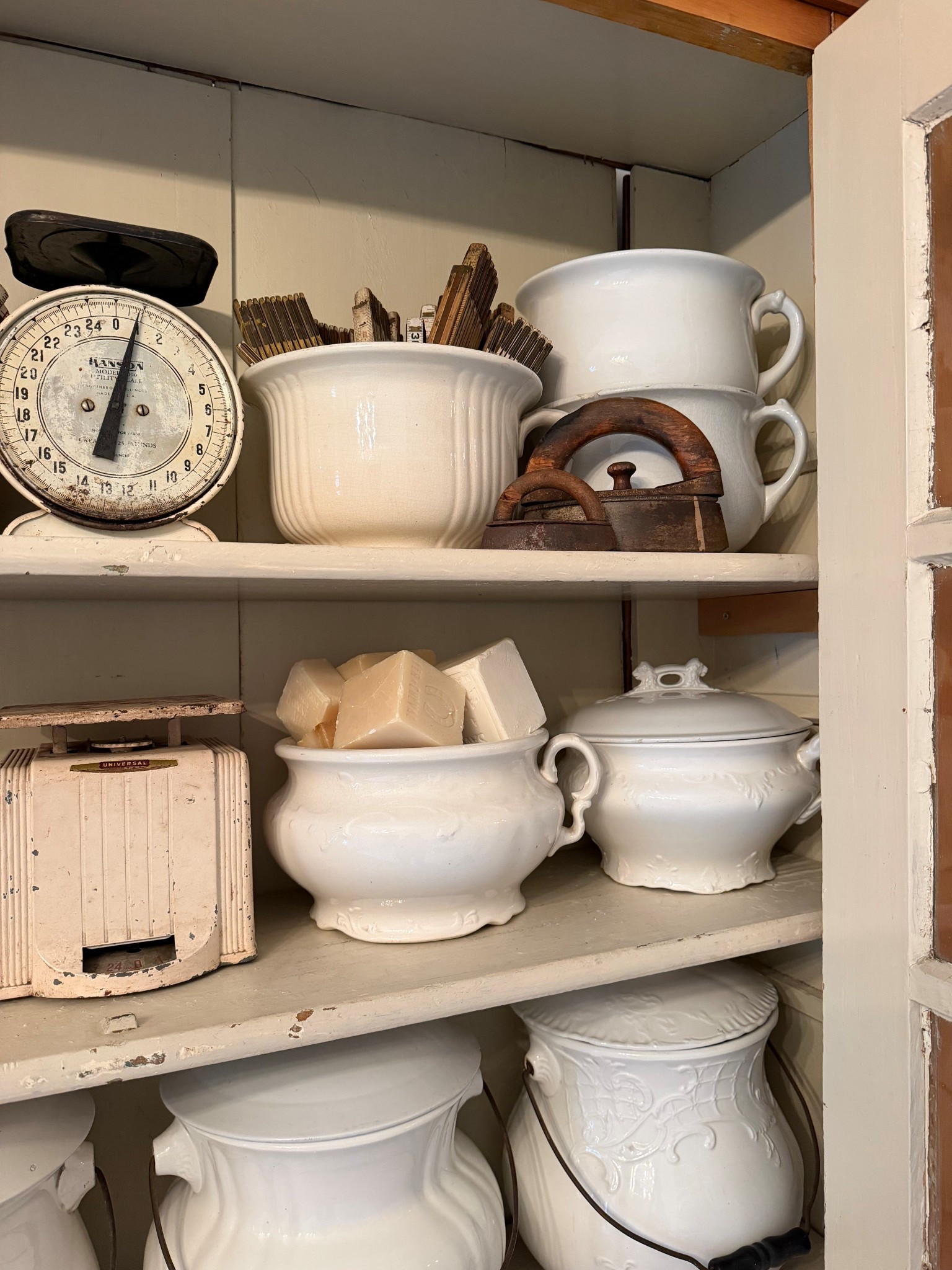 Here are some of the vintage items that I use to decorate this cabinet, including chamber pots, irons, scales, clothes pins, and French soap cubes. 

#LTKHome