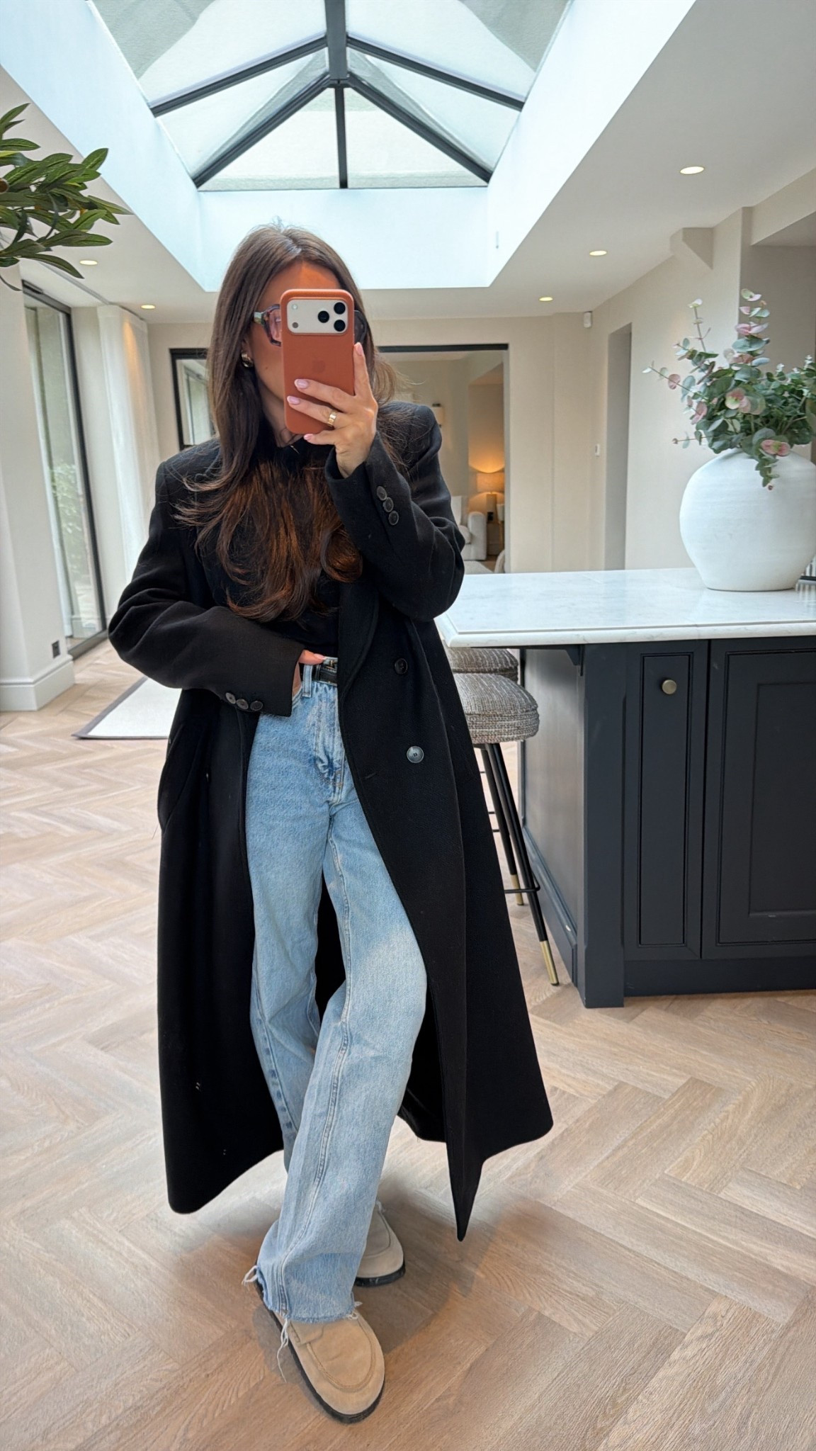 Black long coat, shoulder pads, blue jeans, mules , black polo neck