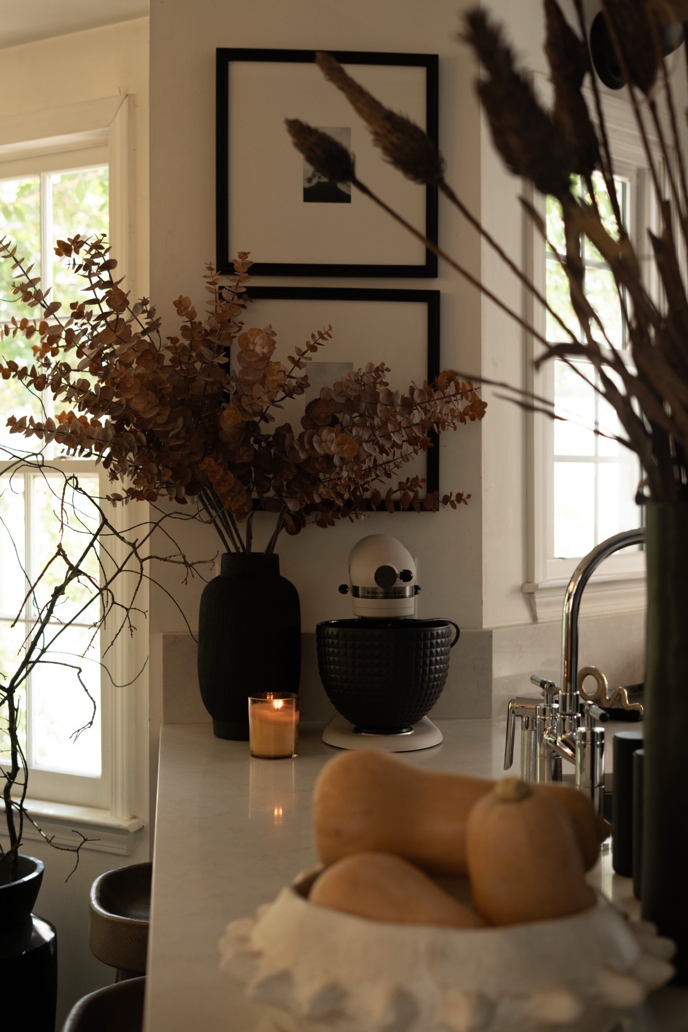 Fall coziness has officially taken over my kitchen! I styled this corner with moody dried florals, warm candlelight, sculptural black accents, and a simple bowl of butternut squash for that effortless autumn charm. The layered textures and neutral tones create a calm, sophisticated vibe that feels both seasonal and timeless. I am loving the sleek black kitchen aid bowl to make some of my favorite fall recipes this season! Let the fall baking commence!  

 #LTKSeasonal #LTKHome #LTKStyleTip