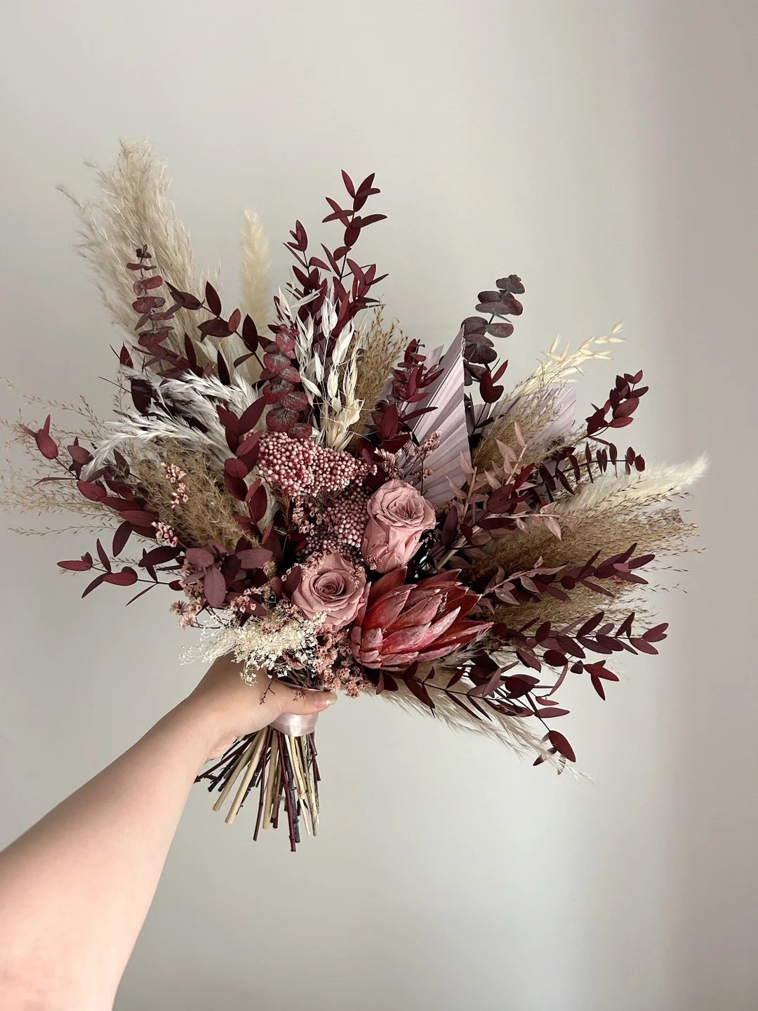 Rich, romantic, and effortlessly elegant 💐 This burgundy and dusty pink bridal bouquet is a stunning blend of pampas grass, palm spears, protea, and soft filler florals for a perfectly balanced, boho-inspired look. Handcrafted locally in Canada with no customs duties or import taxes, it’s a stress-free and timeless choice that adds depth, texture, and unforgettable color to your wedding day.
#LTKWedding #BridalBouquet #BohoBride #DriedFlowers #WeddingFlorals #EtsyFinds #MissFleurs #WeddingInspo

#LTKSeasonal #LTKFindsUnder50 #LTKHome