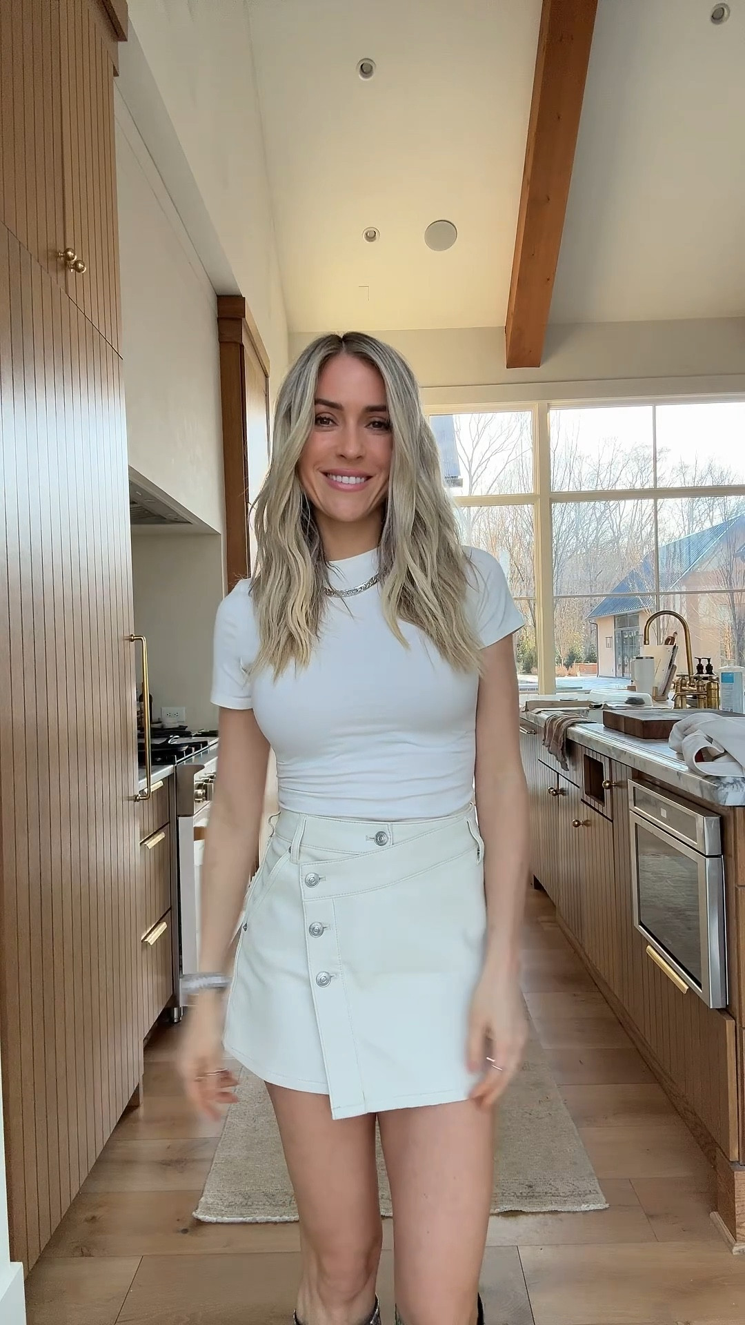 Shop Kristin Cavallari's ￼all neutral outfit wrap faux leather skirt short sleeve white bodysuit python snake print boots woven leather pouch ￼