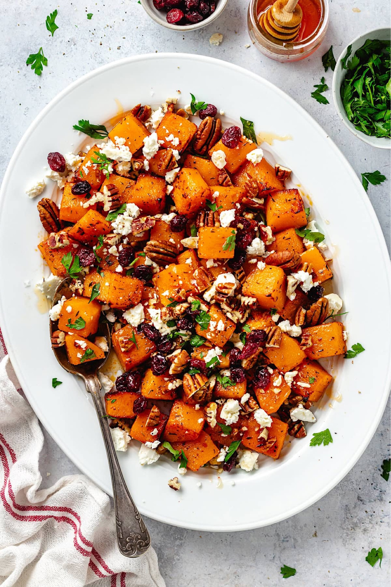 Roasted butternut squash with crunchy pecans, sweet dried cranberries, creamy feta cheese, and a drizzle of hot honey. This simple and sophisticated side dish is perfect for Thanksgiving, Christmas, or served along side any meal. Get the full recipe at TwoPeasAndTheirPod.com!

#LTKFindsUnder100 #LTKHome #LTKSeasonal