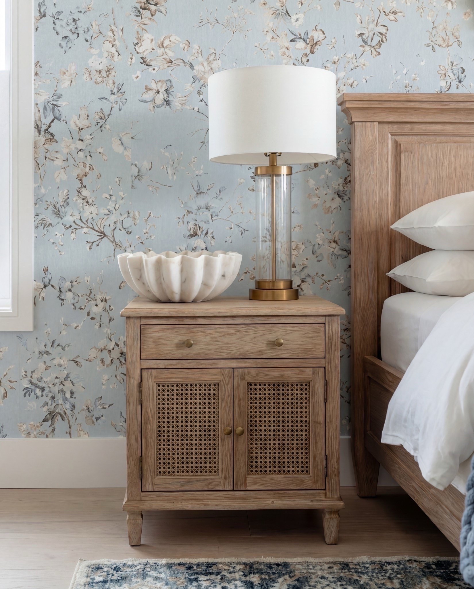 Bedroom Refresh : Shop The Look.
Natural wood bed | Chunky blue knit throw | Patterned blue pillows | Caramel cube ottomans | Blue and neutral patterned rug | Brass beaded mirror | Brass table lamps | Soft floral wallpaper | Natural wood  cane nightstands | Exposed ceiling beams, ribbed white decor bowl. 

#LTKSpringSale #LTKSaleAlert #LTKHome