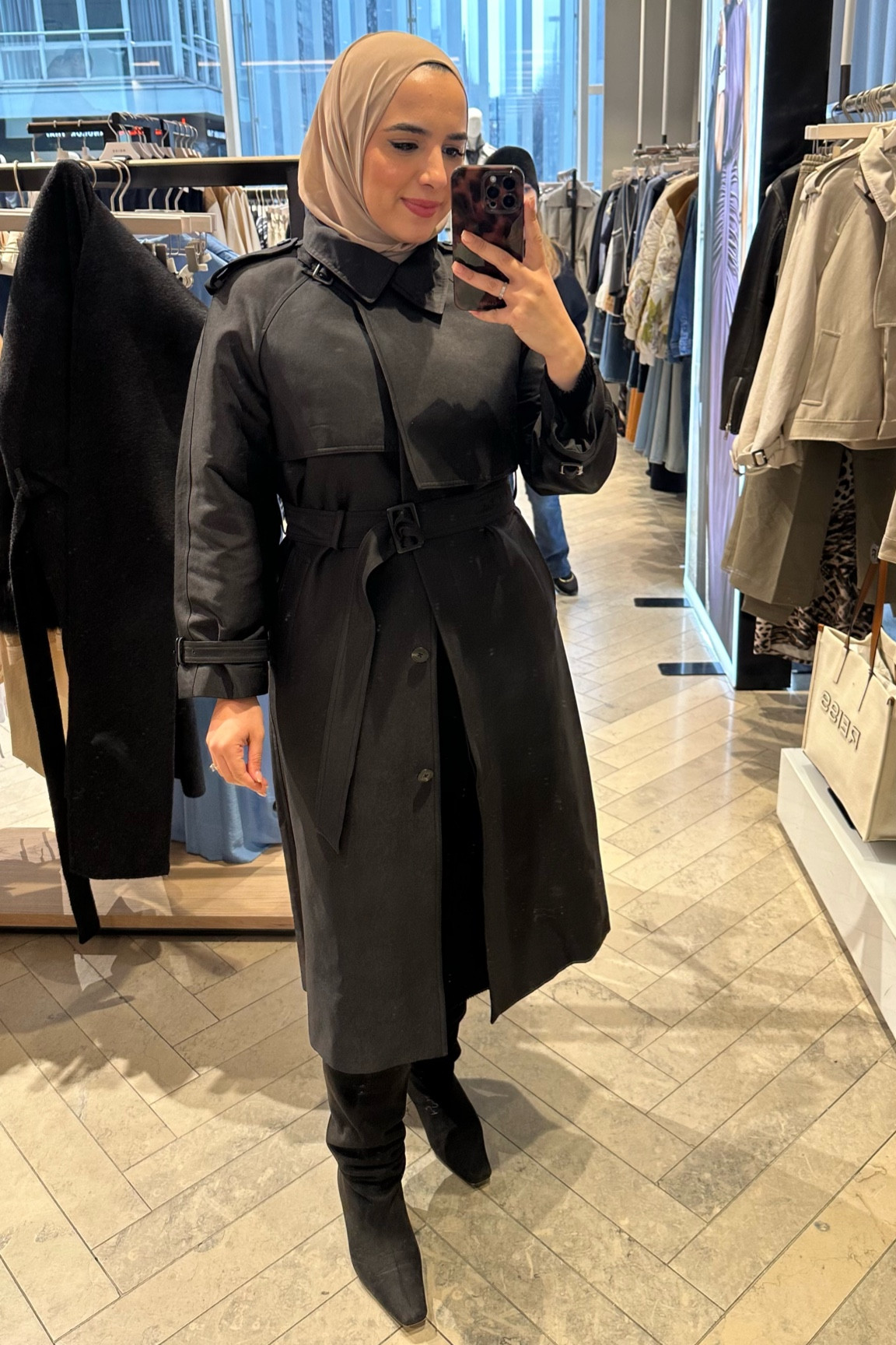 Get you a husband that supports your shopping habits 🖤 this iconic trench coat from @reiss went straight into the shopping basket! 
You could almost wear this trench coat as a dress! It’s giving black cat energy 🐈‍⬛ 
I love the asymmetrical collar with the lapels and the material almost felt like taffeta and had a gorgeous sheen! 

#modestfashion #midsizefashion #hijabstyle #comeshopwithme #comeshoppingwithme #midsizestyle #reiss #trenchcoat 