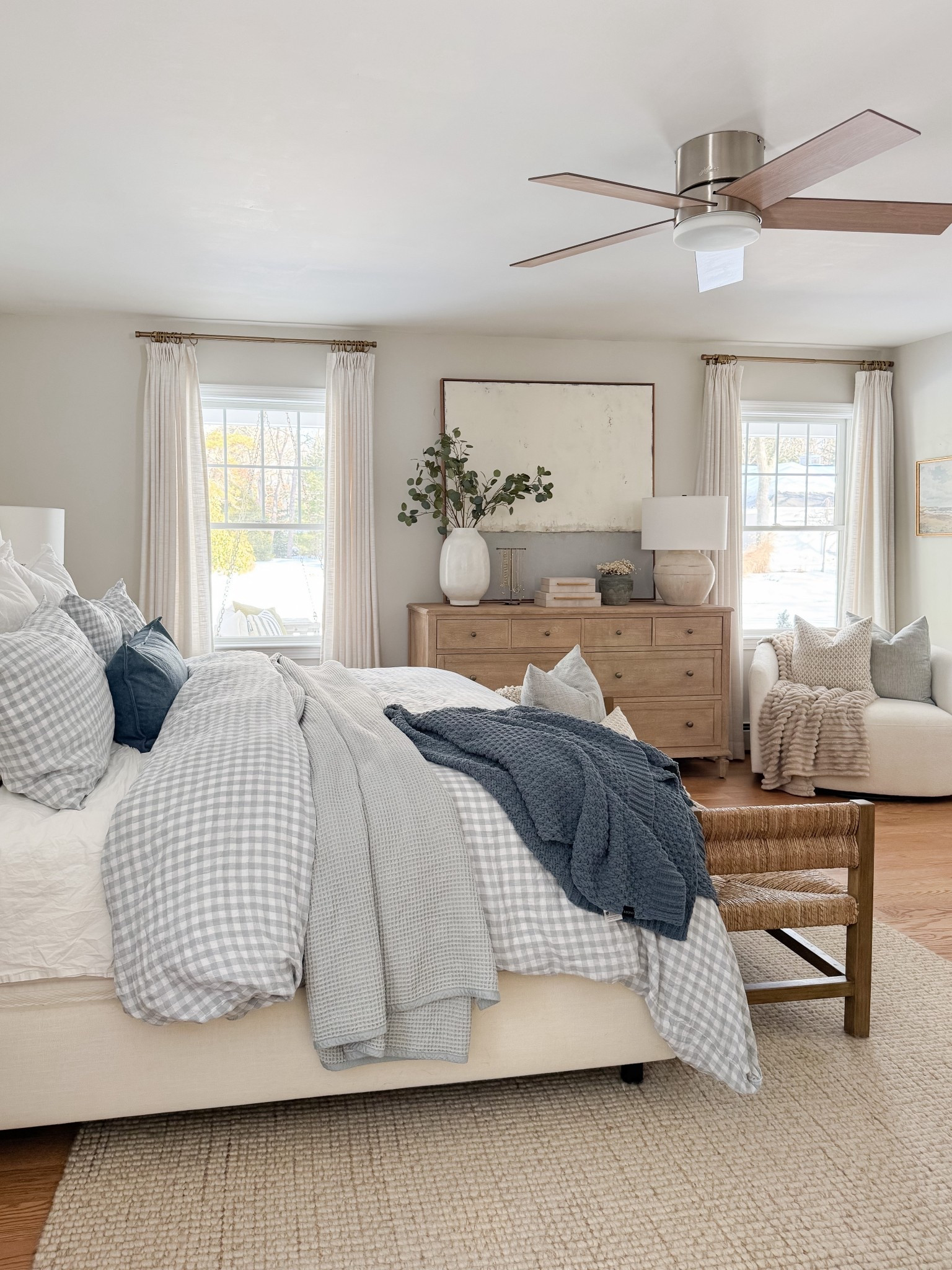 Neutral coastal bedroom with gingham bedding, layered throw blankets, textured knit coverlet, and soft patterned pillows. Light wood nightstands and white table lamps create a calm, layered spring bedroom look. 
gingham bedding, neutral bedroom decor, layered bedding, spring bedding, coastal bedroom, throw blanket, knit coverlet, patterned pillows, light wood nightstands, white table lamps, cozy bedroom, serene bedroom style, sherri calnan home

#LTKHome