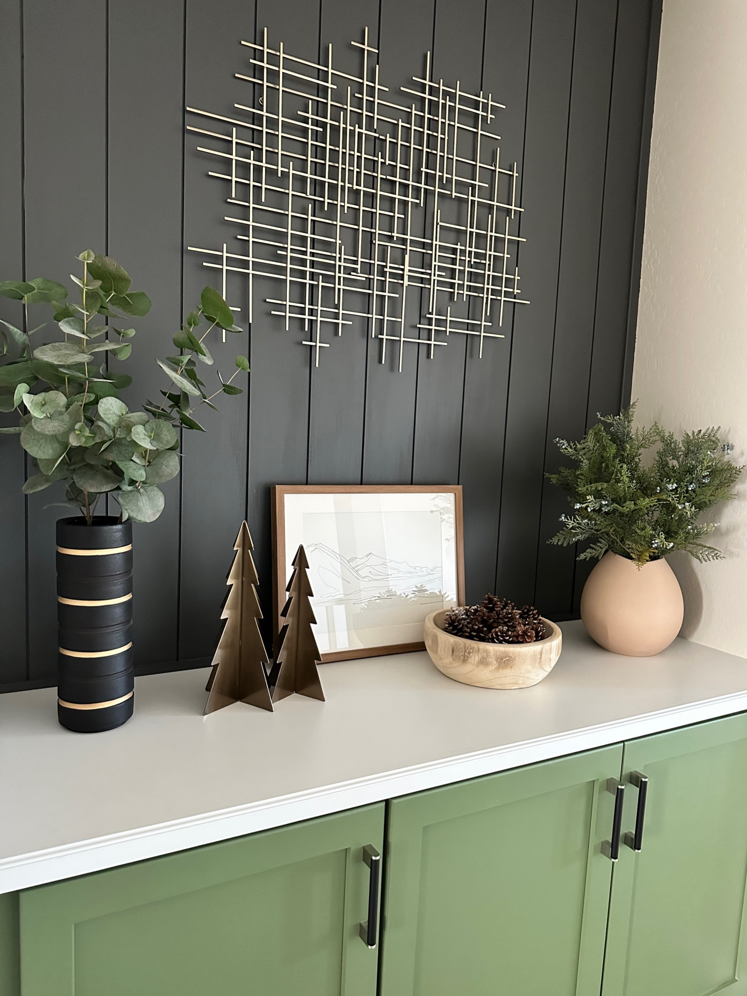 Console table holiday decor styling using pinecones in a wooden bowl, gold metal Christmas trees, faux greenery in vases, framed art, and gold metal art! Neutral Christmas decor. 

#LTKHoliday #LTKSeasonal #LTKhome