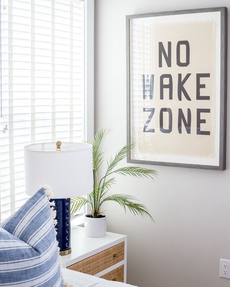 No Wake Zone art and ightstand styling in our beach house vacation rental, Hola Beaches 30A! Our cane nightstand is a budget find and looks so cute with this navy blue ceramic lamp and faux palm plant. Also linking a similar upholstered bed, our white quilt, and blue frayed quilted bedding. Book your stay here: https://www.coastaldreamin.com/479378/.

#ltkhome #ltksalealert #ltkstyletip #ltkfindsunder50 #ltkseasonal #ltkkids #ltkfindsunder100 beach house, lake house art, kids bedroom art

#LTKsalealert #LTKhome #LTKSeasonal