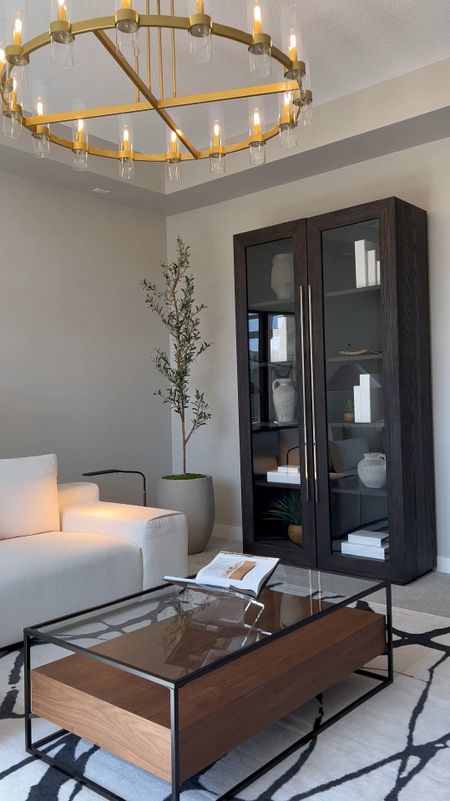 I love incorporating the faux olive tree in each room. Looks amazing in a large cement planter. ☺️ Cream sectional  | RH bookcase | brown coffee table | black and white rug | Amazon deals

#coffeetable
#rhdupe
#olivetree