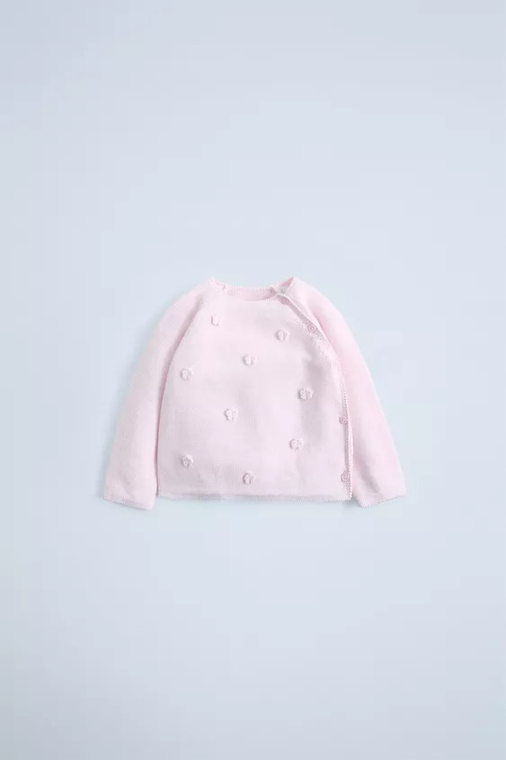 Knit sweater with round neck and long sleeves. Crossover button closure. Floral appliqué on the ... | Zara US