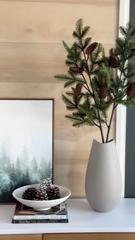 Neutral Console or Side board holiday styling! Minimal Christmas decor of gray vase, faux greenery with pinecones, white bowl with pine cones, art and black metal Christmas tree with ornaments  

#LTKhome #LTKSeasonal #LTKHoliday