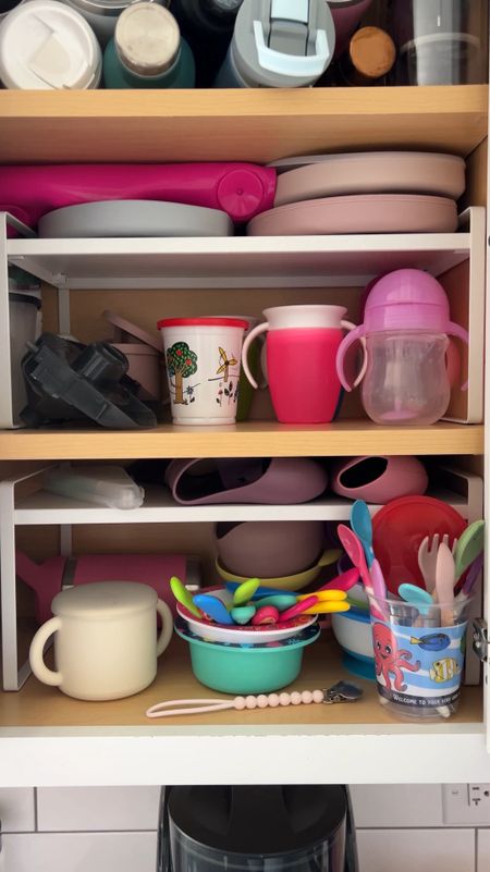 Kitchen cabinet organizer shelving to corral all your toddler feeding essentials. My cabinets aren’t very tall so the small spot between the add in shelving and the cabinet shelving is perfect for silicone bibs and plates, all of the taller items like sippy cups, toddler forks and spoons, snack catchers, etc. are underneath.

Cabinet shelves come in a two pack!