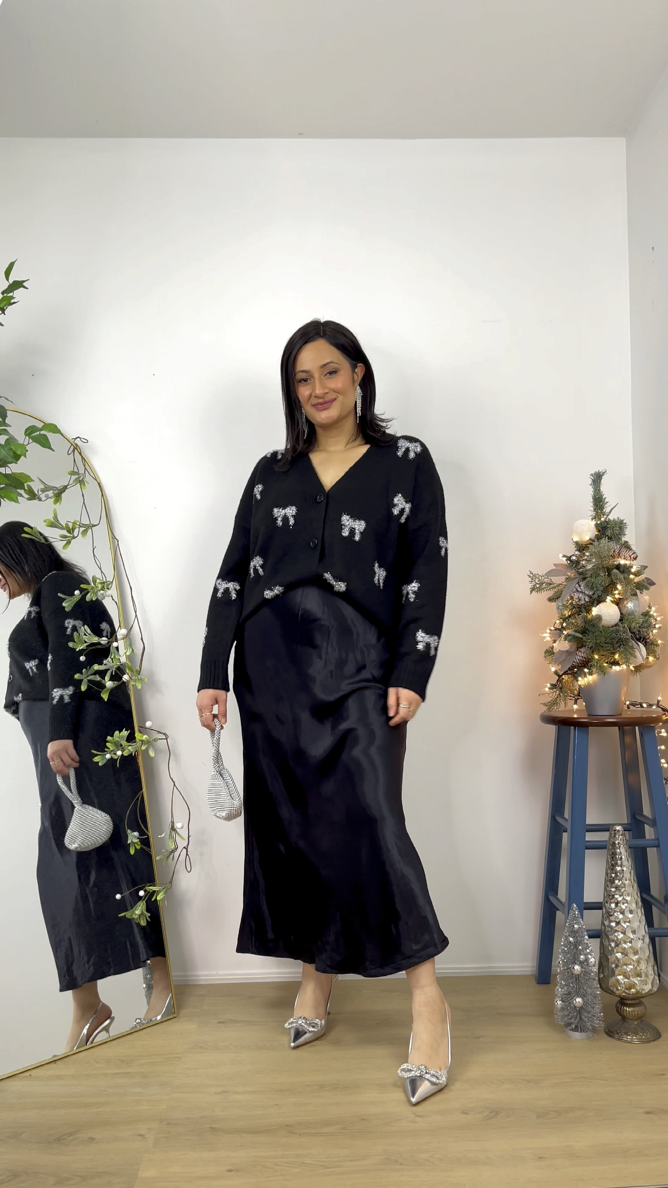 New year Eve outfit inspiration. Outfit idea, festive outfit. New year party, party outfit, holiday look, holiday outfit, go to style, what to wear, midsize outfit, classy outfit, modest outfit, modest fashion. Mix satin skirt from H&M, bow cardigan, silver metallic bow sandals, statement jewelry and accessories 

#LTKHoliday #LTKstyletip #LTKparties