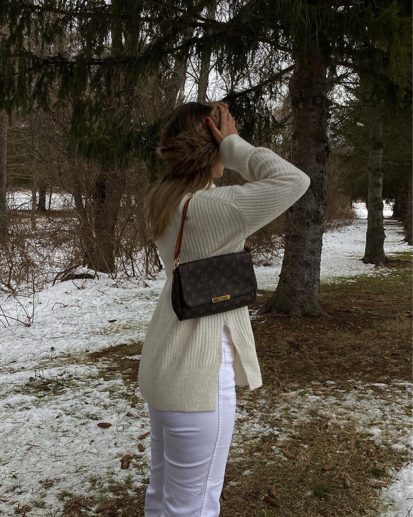 Winter cozy look white high waisted jeans fluffy fur hat and an oversized sweater 
