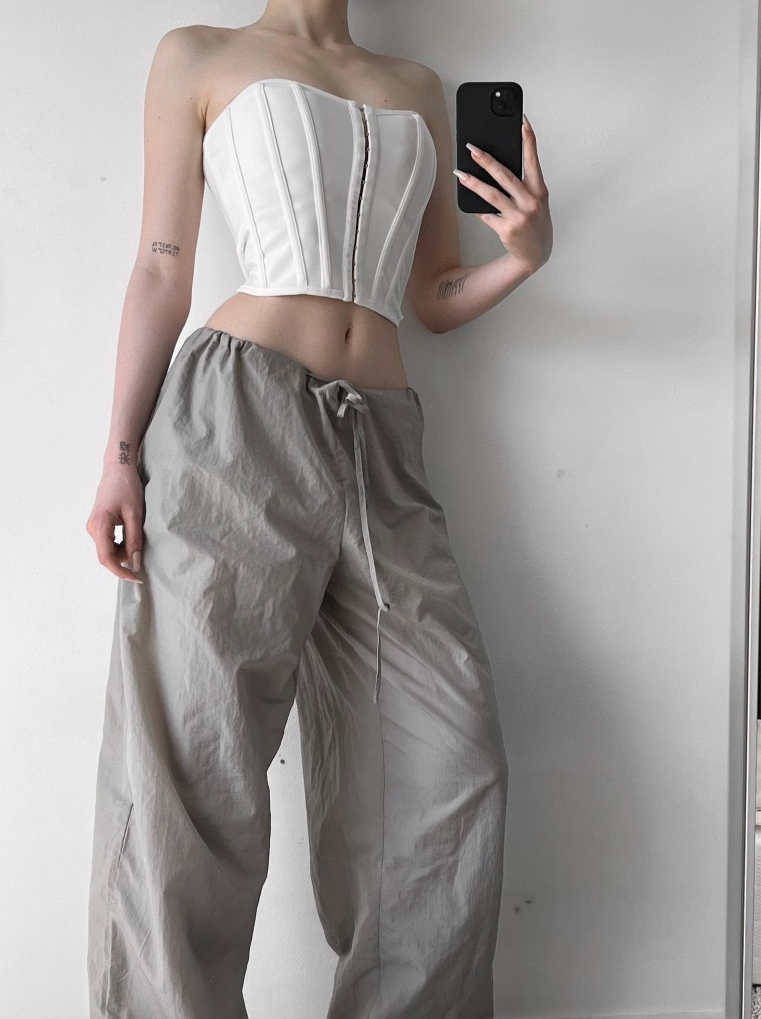 Grey stone low rise parachute pants, charcoal baggy pants, white boned bandage hook and eye corset top, staple pieces, casual outfits, low price, pretty little thing, on sale, street style, flattering 