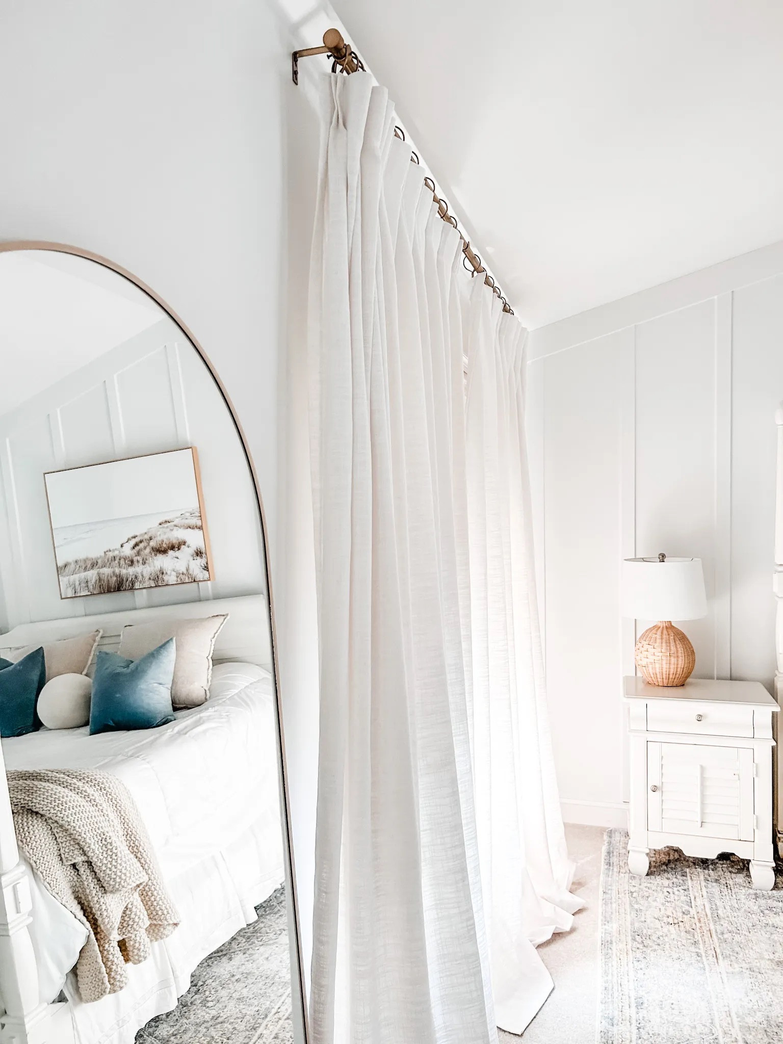 Love our new room darkening curtains in our bedroom from Amazon! 
Also loving the woven Roman bamboo shade that we were able to custom order for the perfect size on Amazon!

Woven shade, bamboo shade, neutral window treatment, Amazon drapes, pinch pleat curtains, faux linen curtains. Curtain clip rings, gold curtain rod, woven Roman shade, arched mirror, floor length mirror, wicker table lamp, bedroom mirror.
#amazon