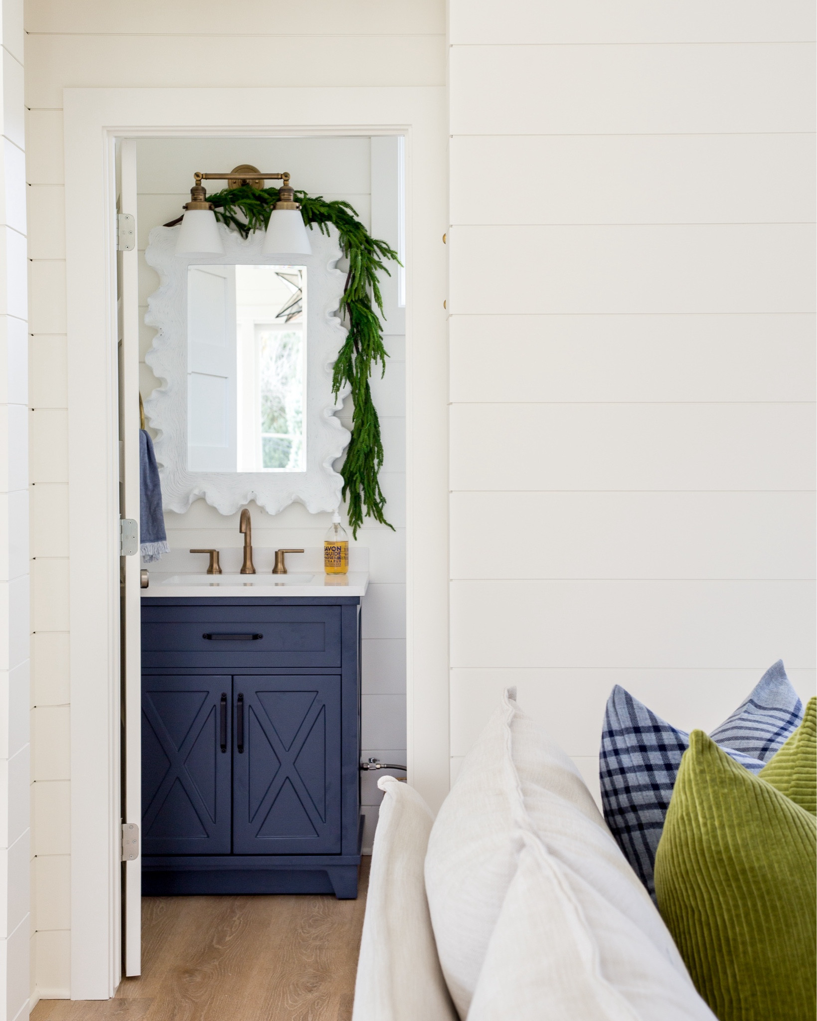 Simple Christmas decor in our Omaha pool house bathroom! I swagged my favorite faux real-touch Norfolk garland over our white scalloped mirror and love the simplicity with our navy blue vanity and gold faucet and light fixture! You can also see our slipcovered sofa, corduroy pillows and plaid pillows! .

#ltkholiday #ltkhome #ltksalealert #ltkfindsunder100 #ltkstyletip #ltkfindsunder50 #ltkseasonal #ltkfamily

#LTKSaleAlert #LTKHoliday #LTKHome