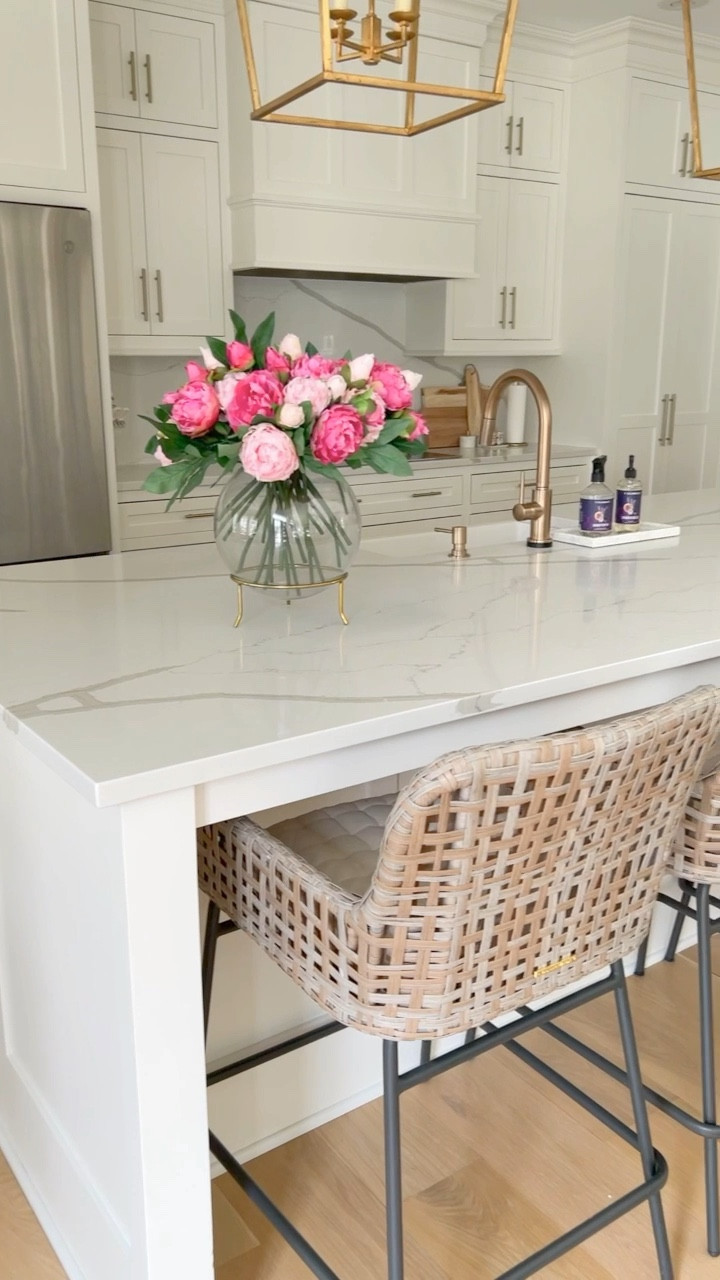 White kitchen cabinets, gold faucet and hardware, faux peonies pink, kid friendly kitchen stools, quartz countertops

#LTKhome #LTKunder100 #LTKFind