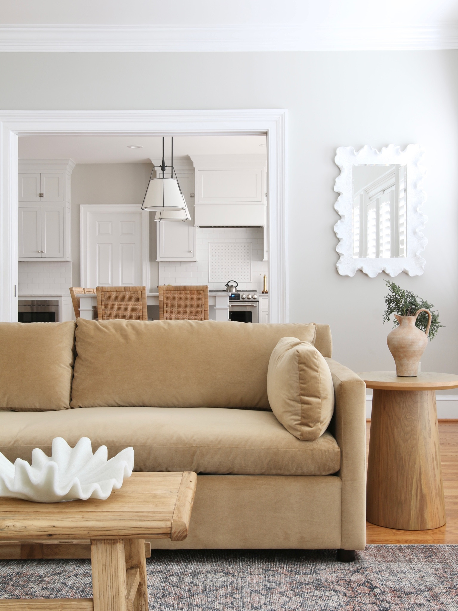Here is the transition from living room to kitchen. I originally had the West Elm Marin sofa in this position next to the Target pedestal side table. The table is reclaimed wood from Amazon and the scalloped bowl is from Lulu and Georgia. The scalloped mirror is from Ballard Designs 

#LTKhome #LTKstyletip #LTKFind
