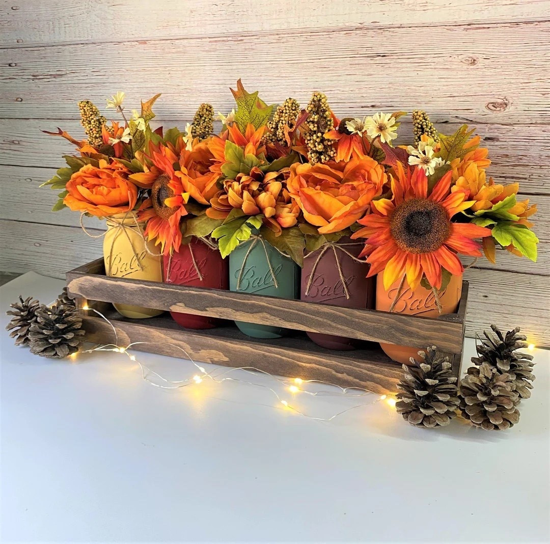 Bring the warmth of autumn right into your home with these charming mason jar floral arrangements from DesignedArrangements 🍂🌻. Each jar bursts with lifelike sunflowers, mums, peonies, and seasonal blooms, all nestled in a rustic tray of your choice—galvanized metal, thin, thick, or two-tier. The jars themselves come in fall-perfect colors, and you can even request custom shades to match your space. A beautiful, high-quality piece that makes an inviting centerpiece or a thoughtful gift!

#FallDecor #MasonJarArrangements #RusticHomeDecor #AutumnCenterpiece #EtsyFinds #DesignedArrangements

#LTKFindsUnder100 #LTKHome #LTKSeasonal