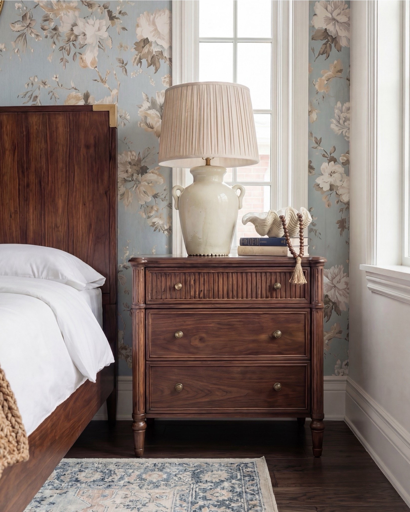 Bedroom Refresh : Shop The Look.
This bedroom is giving soft serenity with a touch of old-world charm. The blue floral wallpaper instantly sets a calming tone, bringing in that fresh, airy feeling while still feeling warm and romantic. The dark wood bed adds richness and depth, and the brass accents give it that quiet luxury moment.

The chunky knit throw brings all the coziness, and the bouclé stools at the foot of the bed add just the right amount of texture. And can we talk about the ceiling? Those exposed beams make the entire room feel architectural, grounded, and so intentional.

The window seat is the sweetest finishing touch — layered pillows, soft drapery, and the perfect nook for slow mornings. Every detail feels thoughtful, calm, and beautifully timeless.

Shop the Look:
• Blue floral wallpaper
• Dark wood bed with brass accents
• Cream bouclé round stools
• Chunky knit camel throw
• Neutral patterned area rug
• Light wood + ceramic table lamps
• Brass round wall mirror
• Window seat pillows in warm neutrals

#LTKhome #LTKsale #LTKstyletip