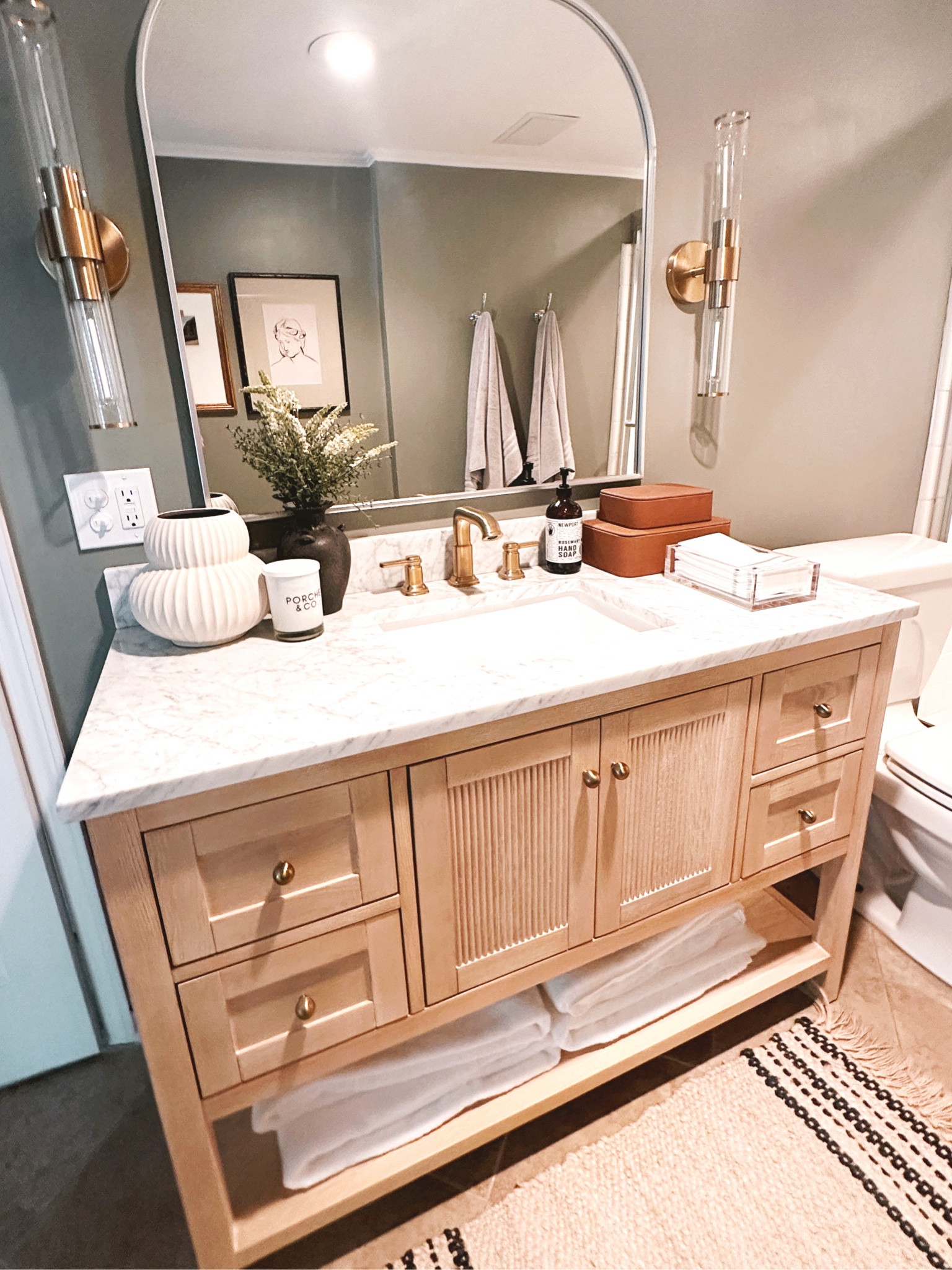 Bathroom makeover with The @homedepot complete with wooden fluted vanity with a cararra marble top, a brass modern faucet, plush bath towels, an arch mirror and gorgeous brass sconces- upgrade your bath room and your home today with amazing Summer savings from The Home Depot 🤍 #bath #bathroom #thehomedepot #thehomedepotpartner #partner

#LTKStyleTip #LTKSaleAlert #LTKHome