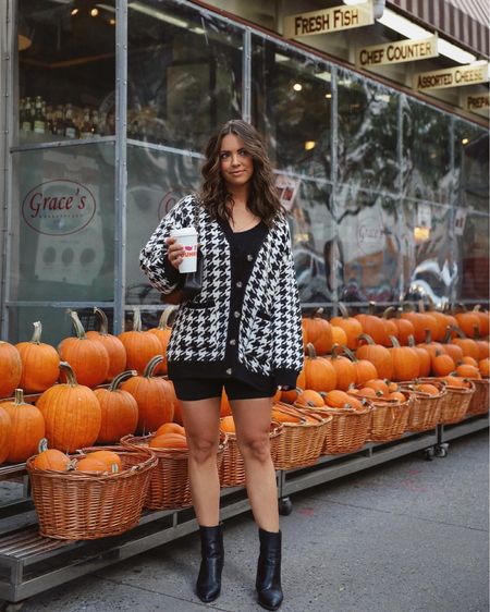 Fall outfit inspo. Oversized cardigan, black boots, bike shorts 