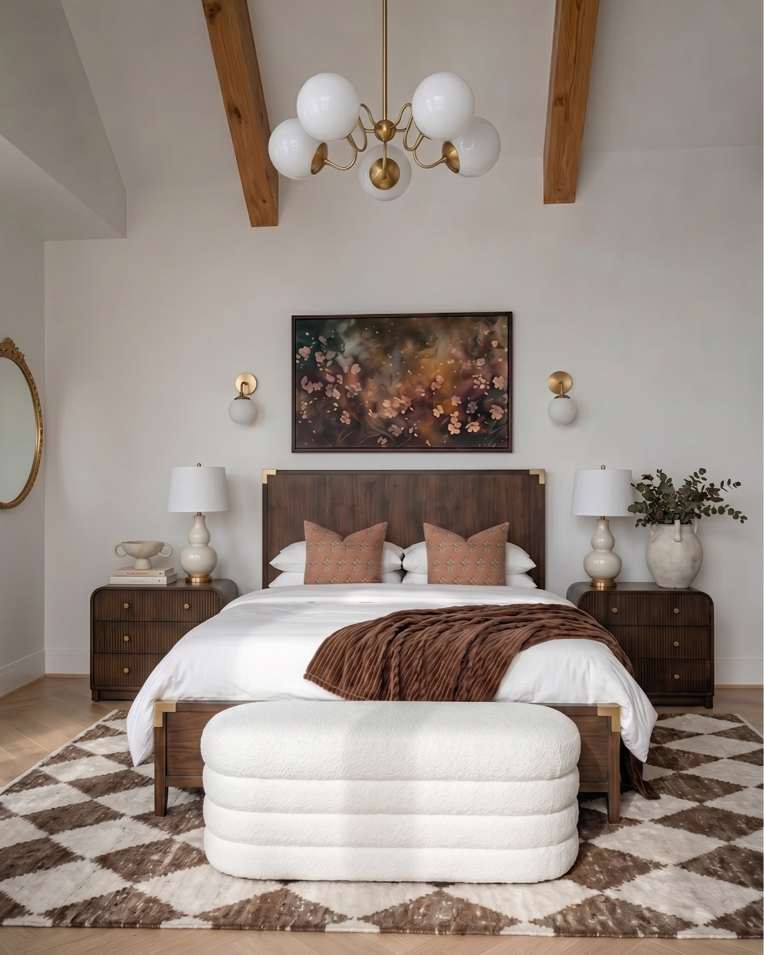Warm modern bedroom design featuring a rich wood bed frame with brass accents, styled with crisp white bedding, textured neutral throw blanket, and terracotta accent pillows for a cozy, elevated look. A plush upholstered bench adds softness at the foot of the bed, layered over a geometric brown and cream area rug.
Matching wood nightstands with fluted detailing are styled with ceramic table lamps, decorative vases, and stacked books for a balanced, designer feel. Above the bed, a statement abstract art piece ties together warm earthy tones, complemented by modern brass wall sconces.
The space continues with a coordinating fluted wood dresser styled with neutral ceramic decor, a framed botanical print, a glass hurricane candle holder, and a decorative tray with small accessories. A cozy accent chair with soft upholstery and wood frame pairs perfectly with a matching round side table, topped with a candle for a warm, inviting touch.
 modern bedroom furniture, warm neutral bedroom decor, wood bed frame, upholstered bench, fluted dresser, designer nightstand styling, ceramic table lamps, abstract wall art, brass wall sconces, cozy accent chair, neutral home decor, earthy tone bedroom, luxury bedroom styling, high-end furniture look for less, transitional modern decor.

#LTKsale #LTKhome #LTKstyletip