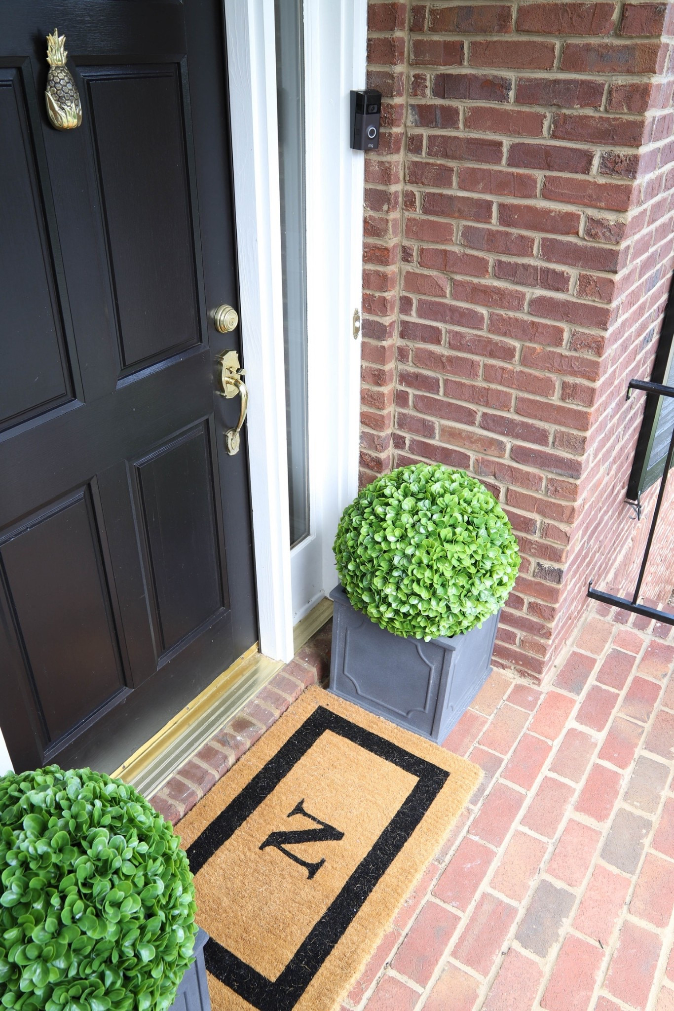 I have a classic monogrammed door mat at my front door with faux boxwoods on either side. 

#LTKMidsize